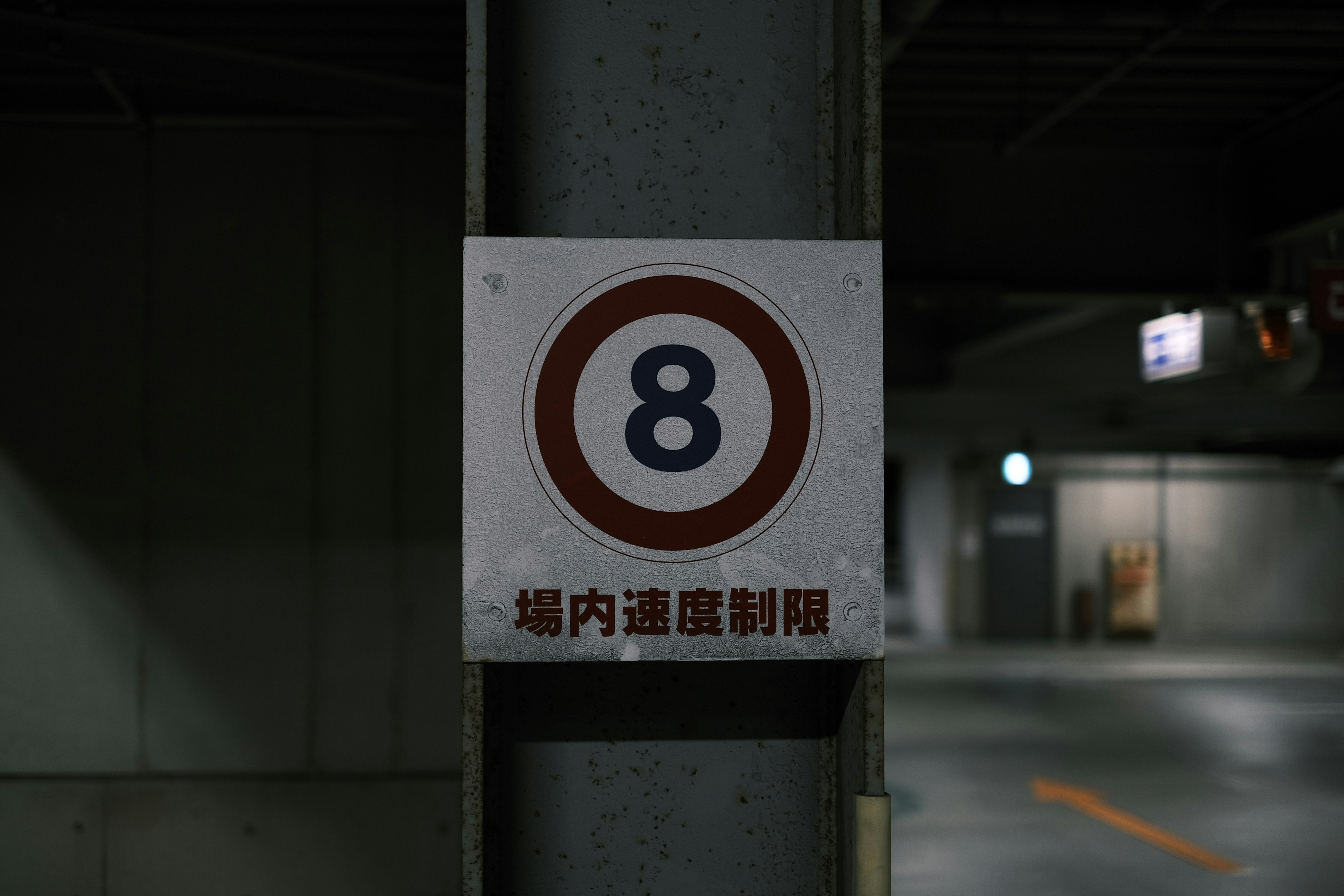 Sign with number 8 mounted on a parking lot pillar