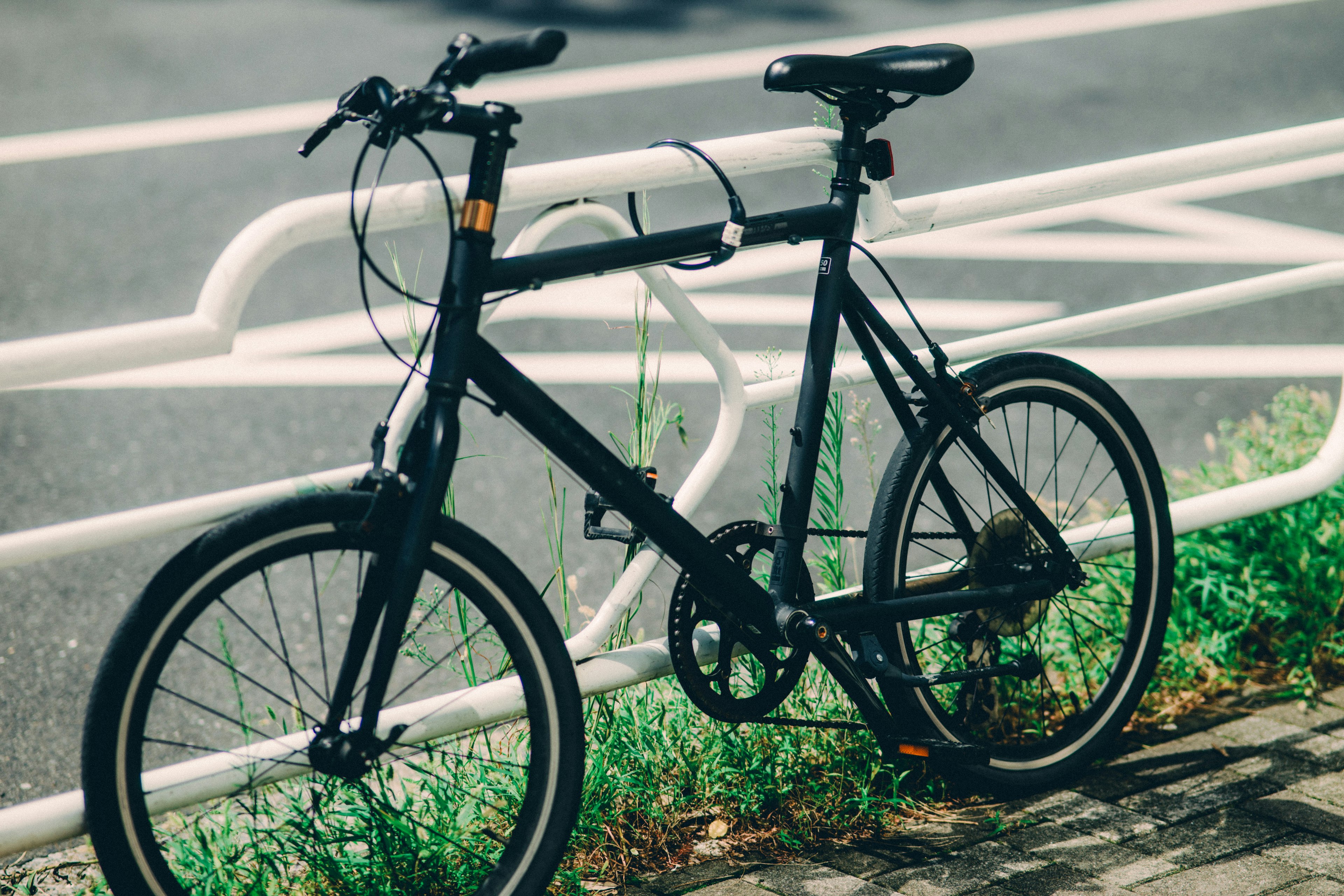 黒い自転車が道路の横に停まっている