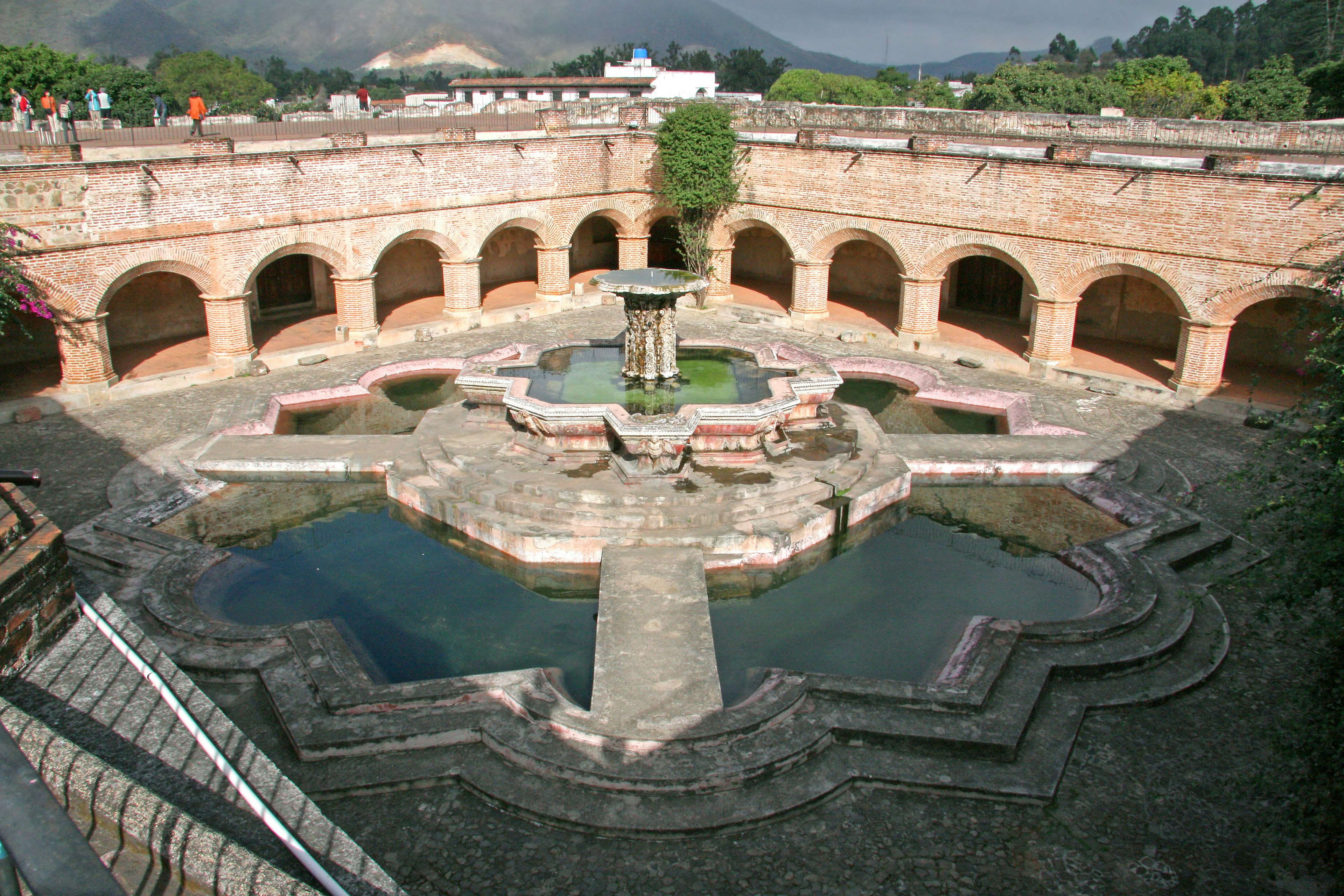 Ancient water reservoir with arched structures and garden