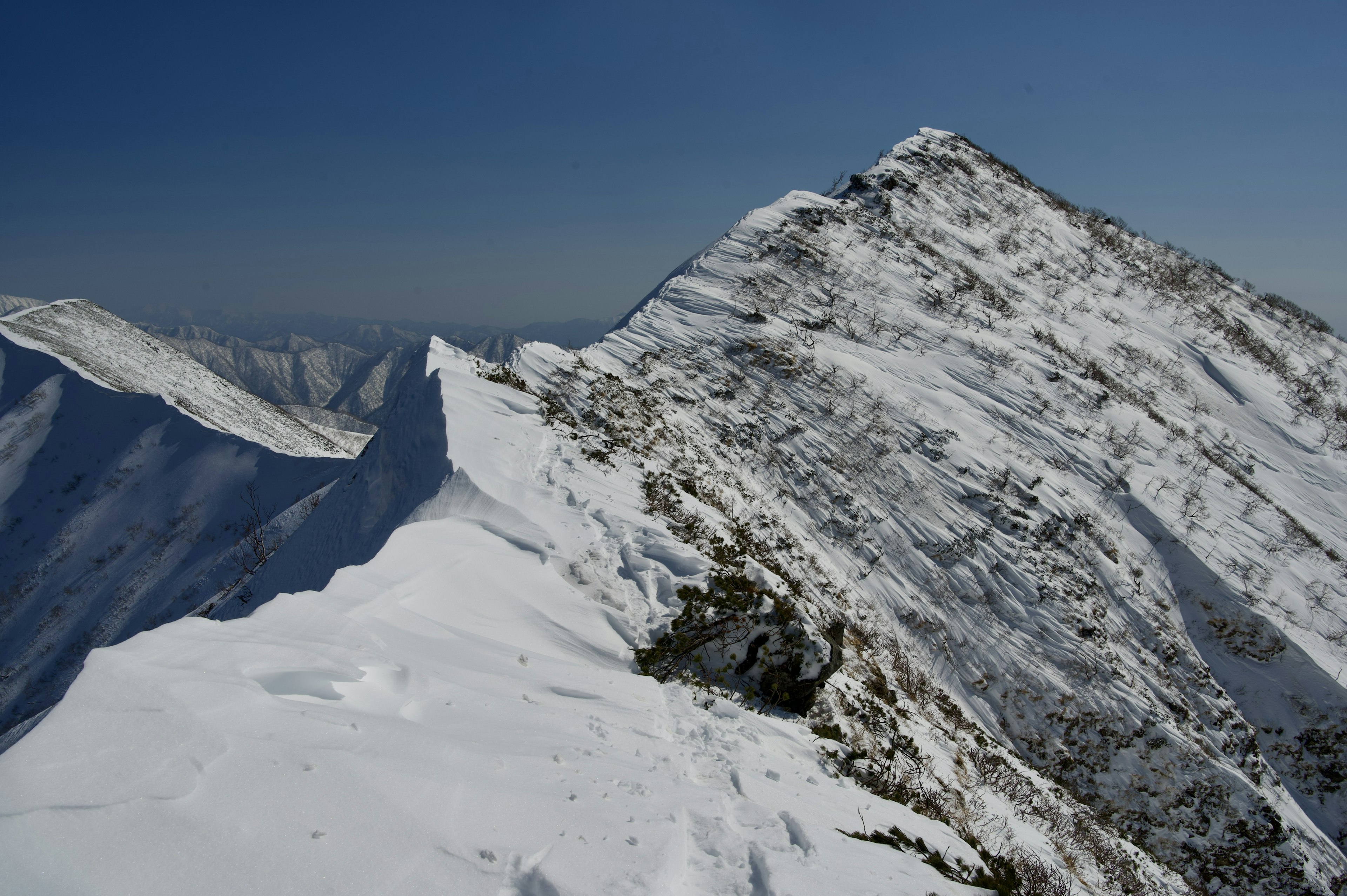 Schneebedeckter Berggipfel mit klarem blauen Himmel