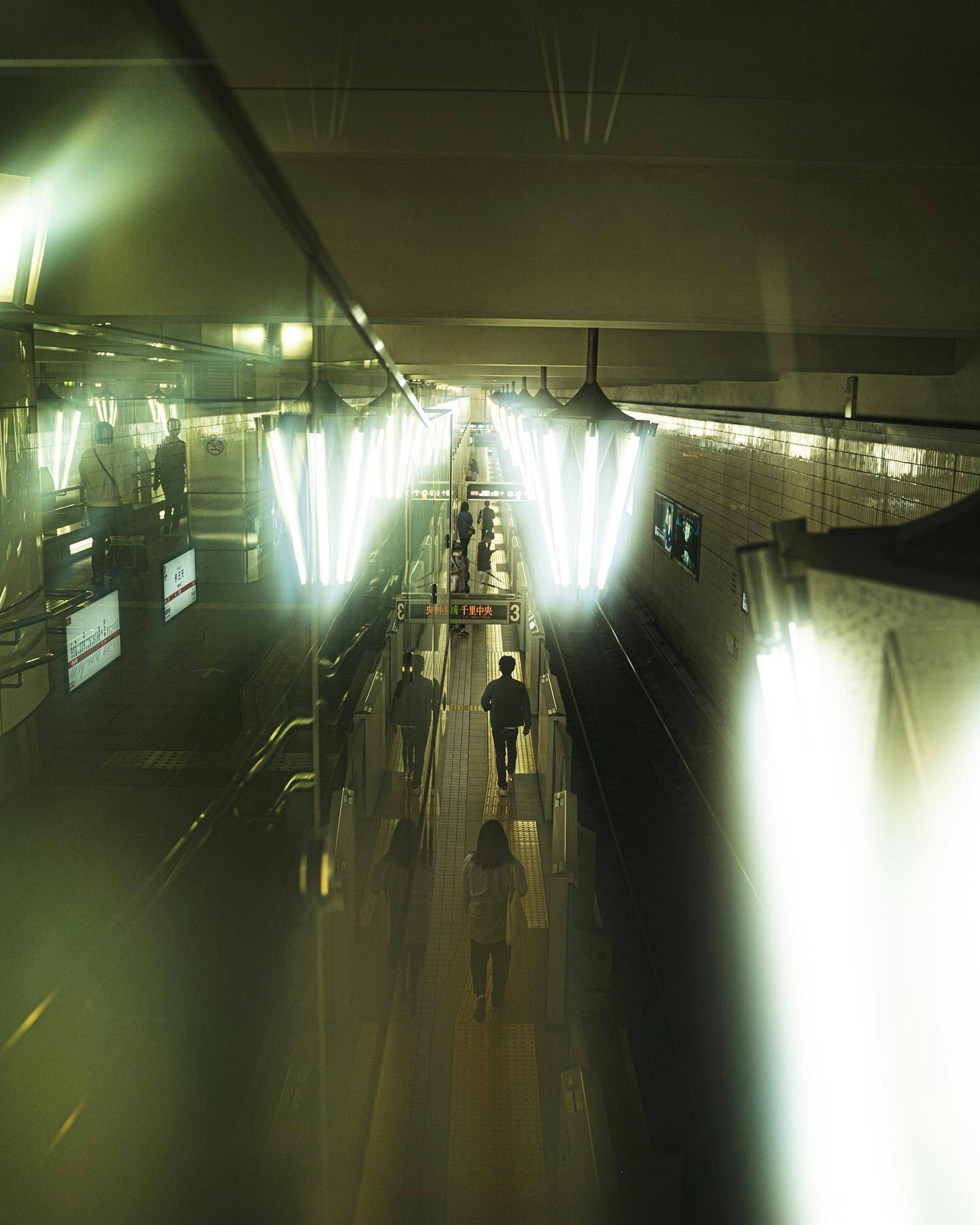 A bustling train station corridor with people walking and bright lighting