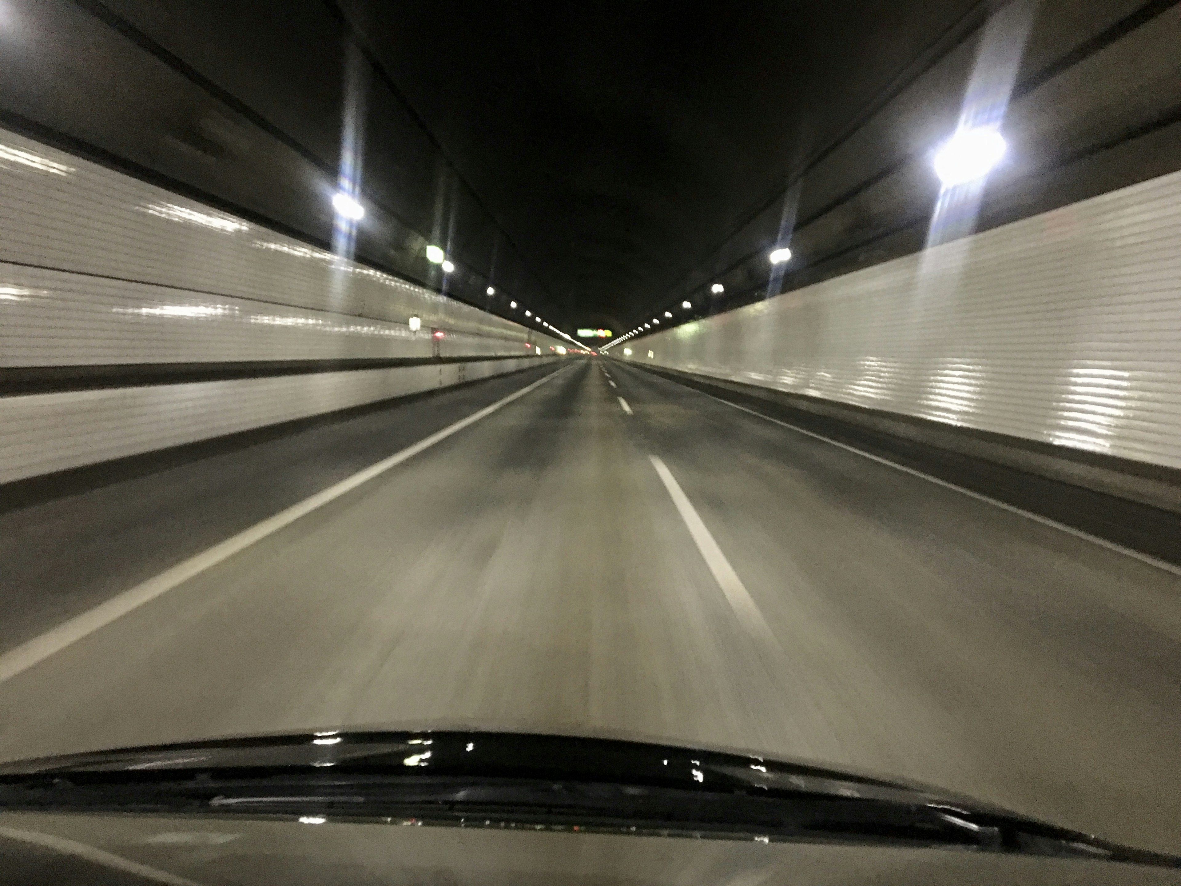 Vista di una strada all'interno di un tunnel con luci brillanti e pavimentazione liscia