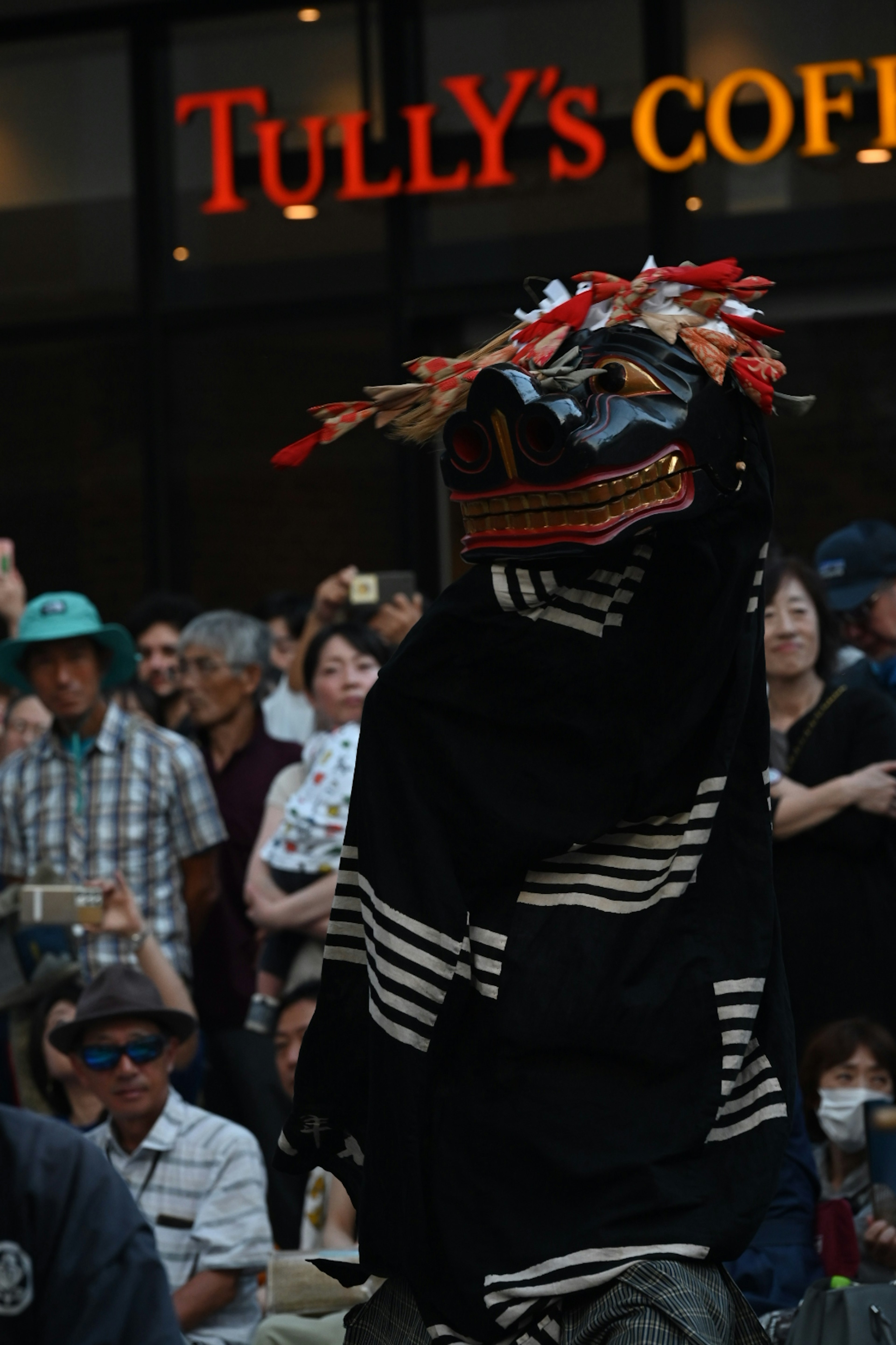 Un artista in abiti tradizionali che danza di fronte a un pubblico