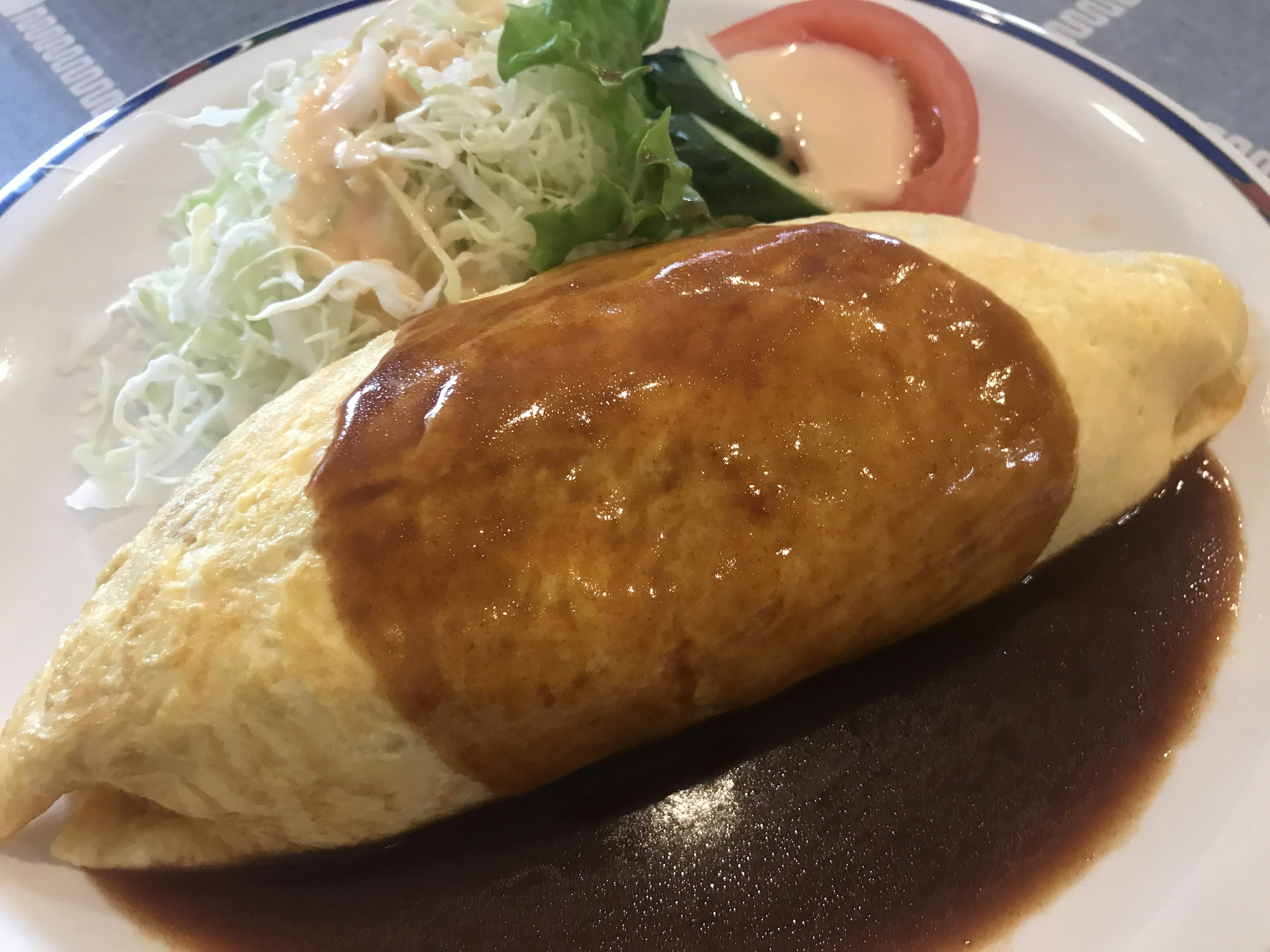 Omelet nasi dengan salad samping dan tomat serta saus