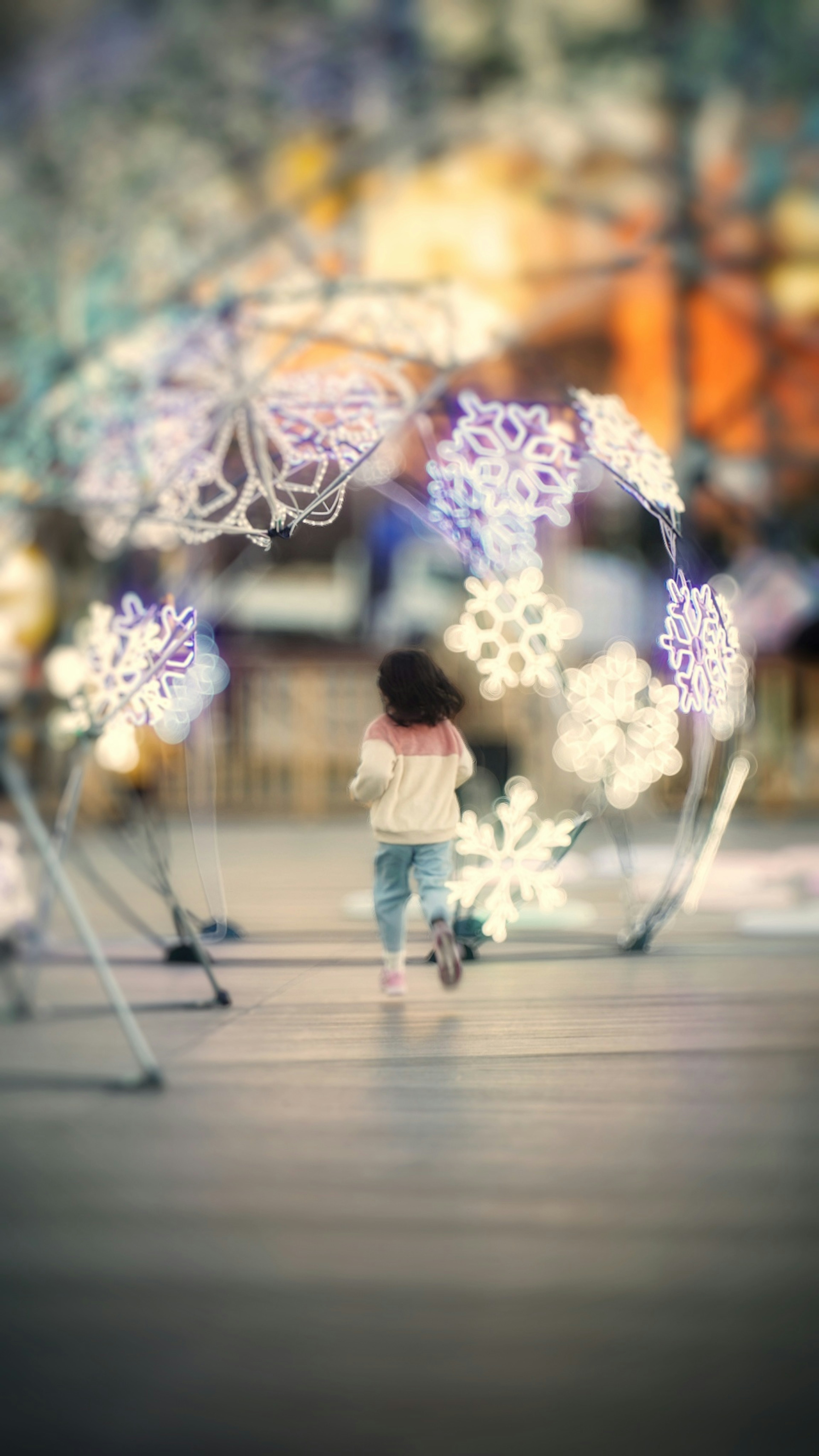 Un niño caminando bajo decoraciones luminosas caprichosas