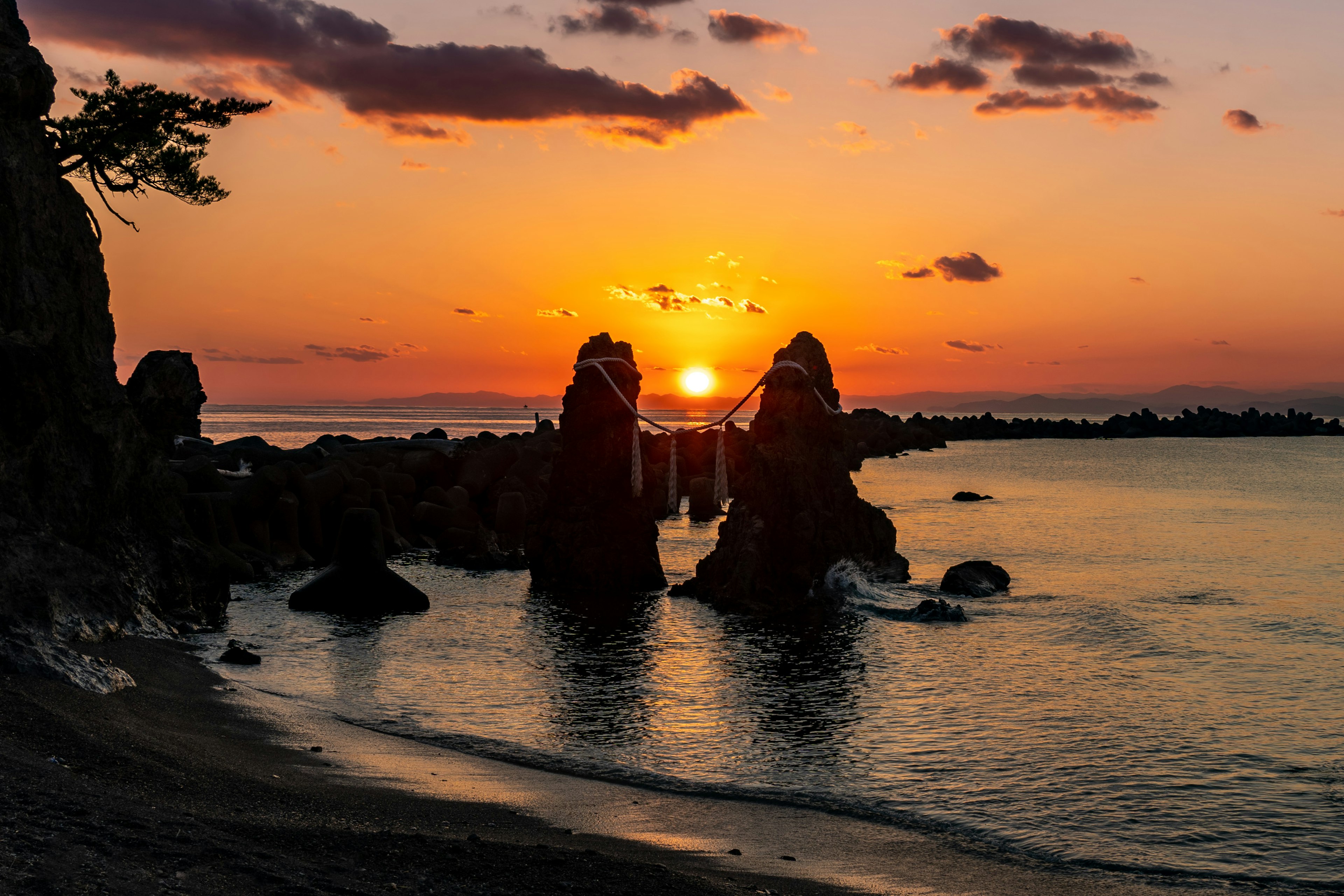 海上日落與前景中的岩石