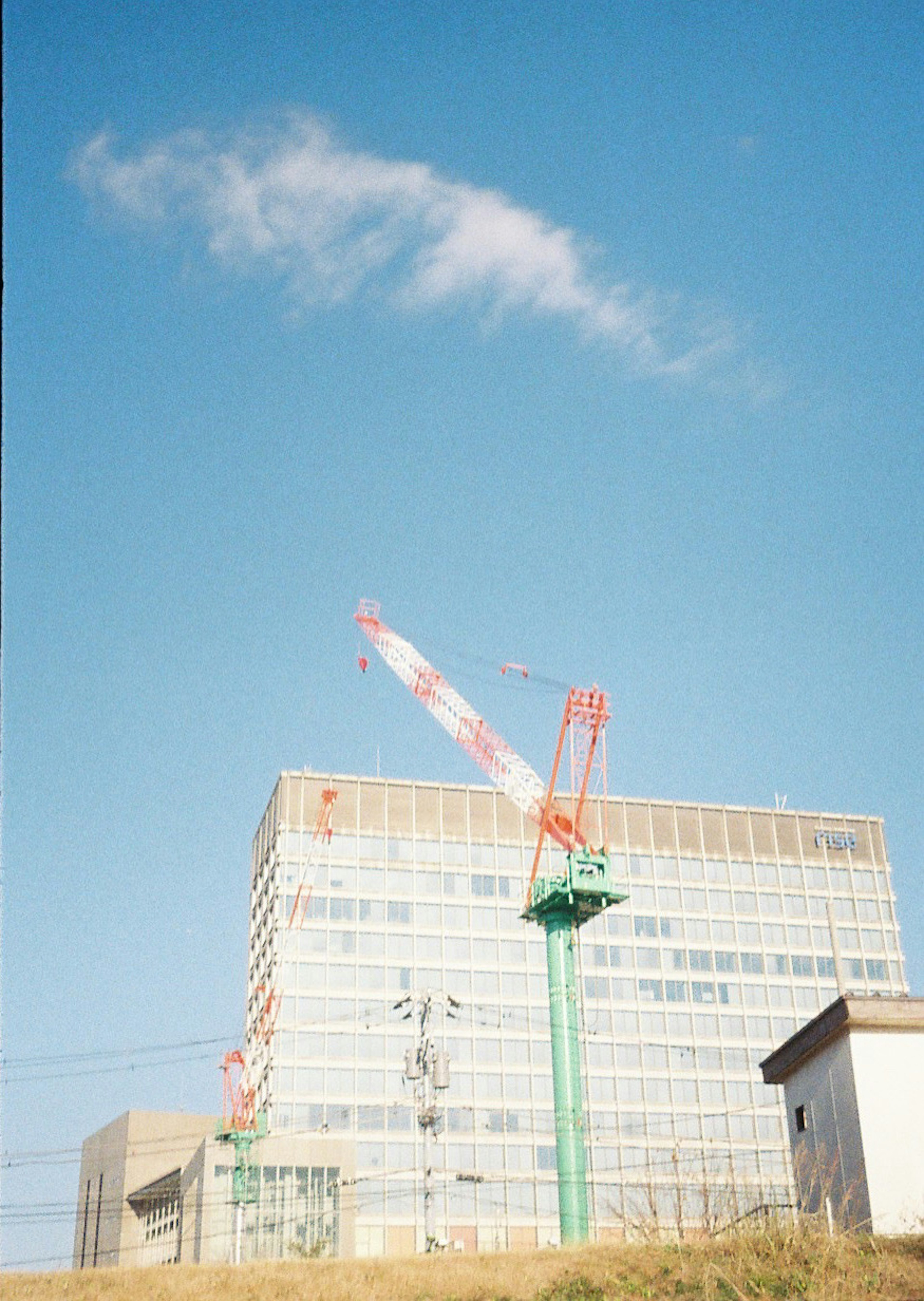 Baustelle mit einem Gebäude und einem Kran unter blauem Himmel