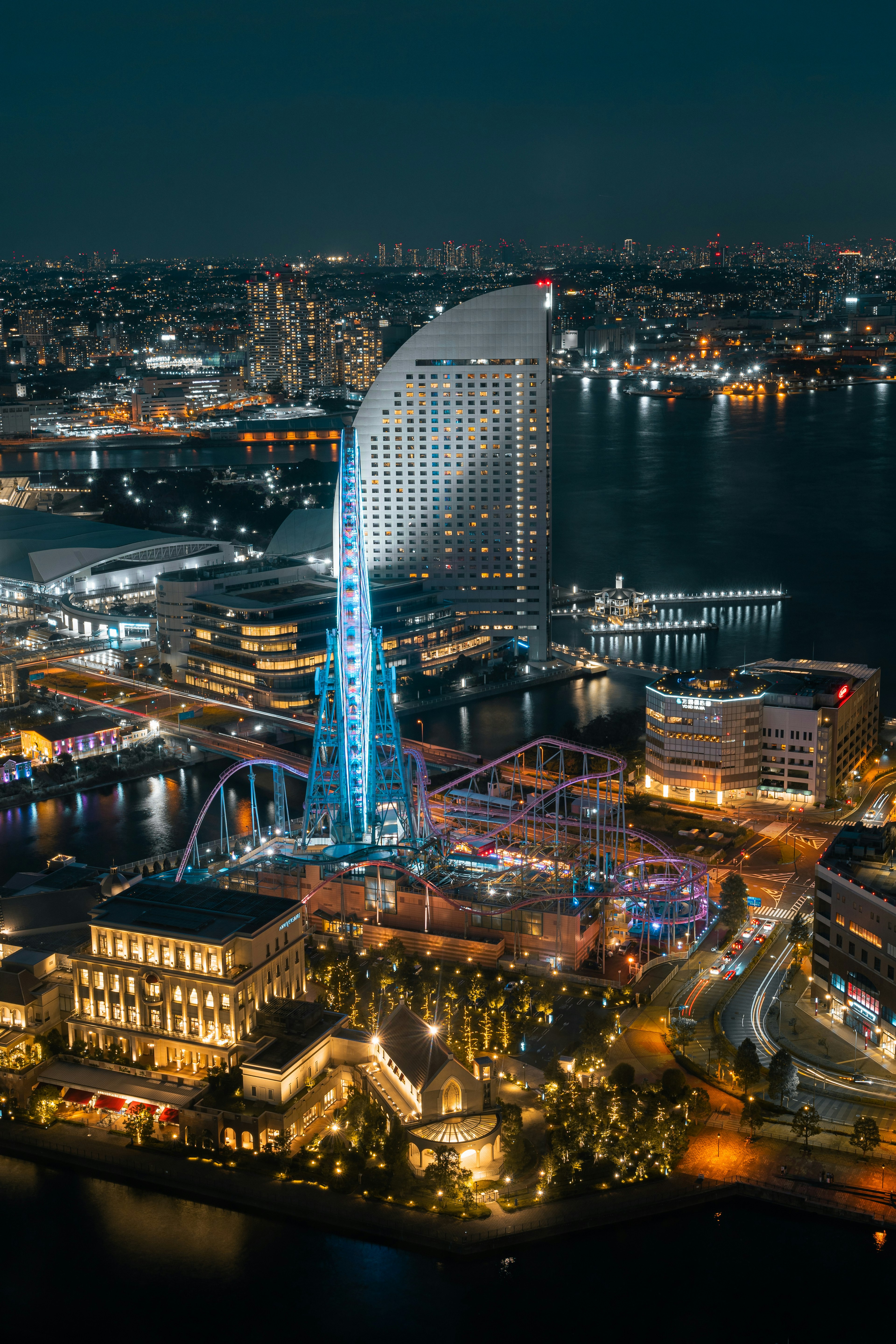 Impresionante vista nocturna de Yokohama con un rascacielos emblemático y atracciones iluminadas