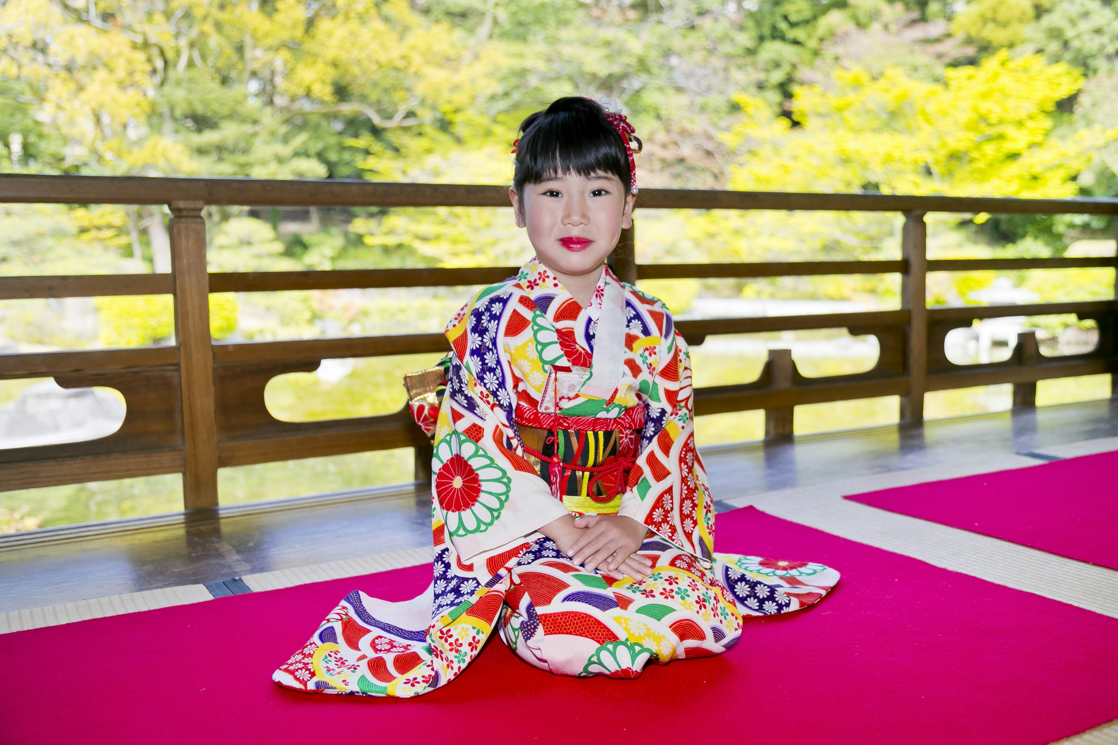 Một cô gái trẻ mặc kimono nhiều màu sắc ngồi một cách duyên dáng