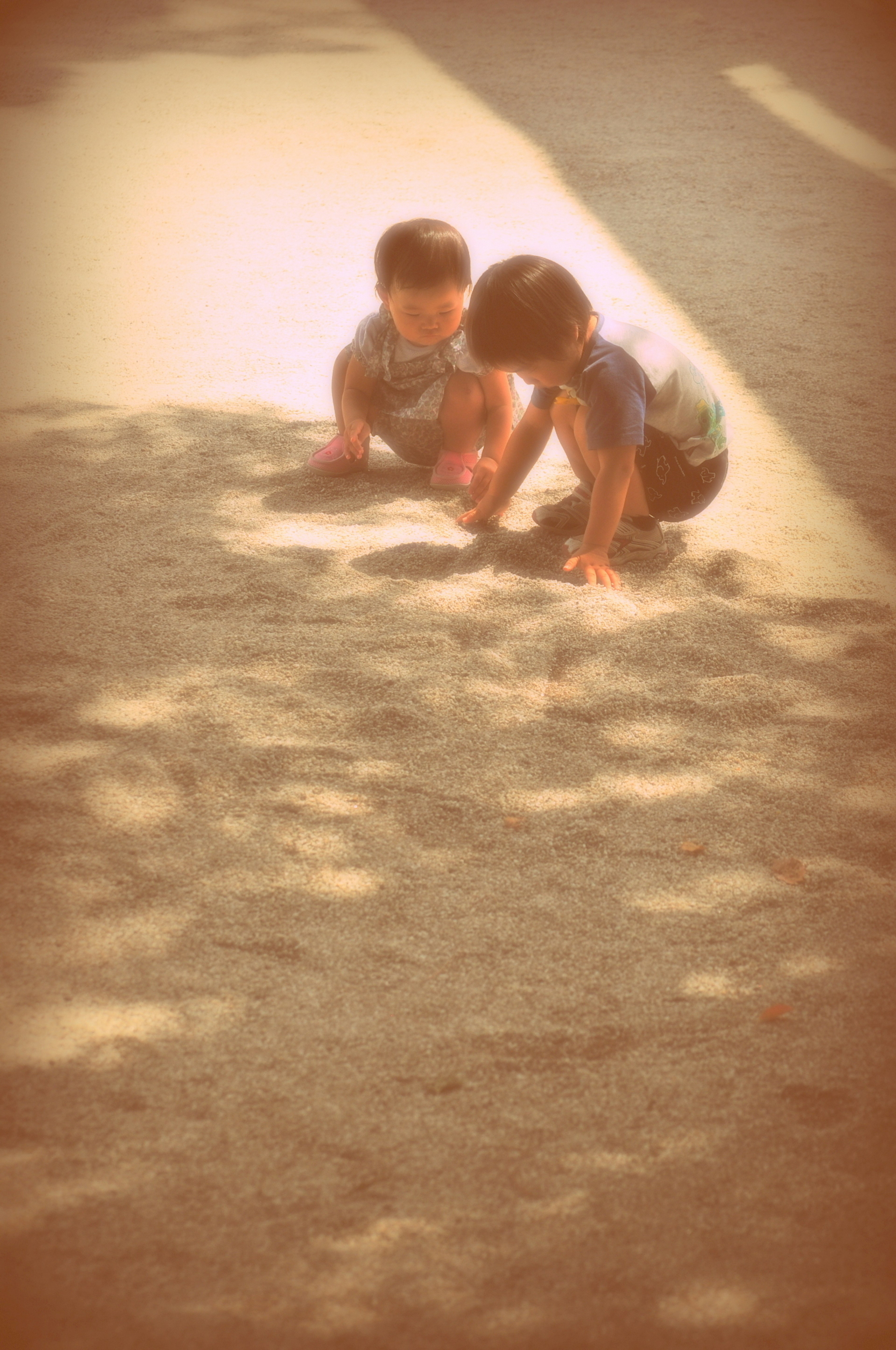 Two children playing on the ground in a soft-focus image