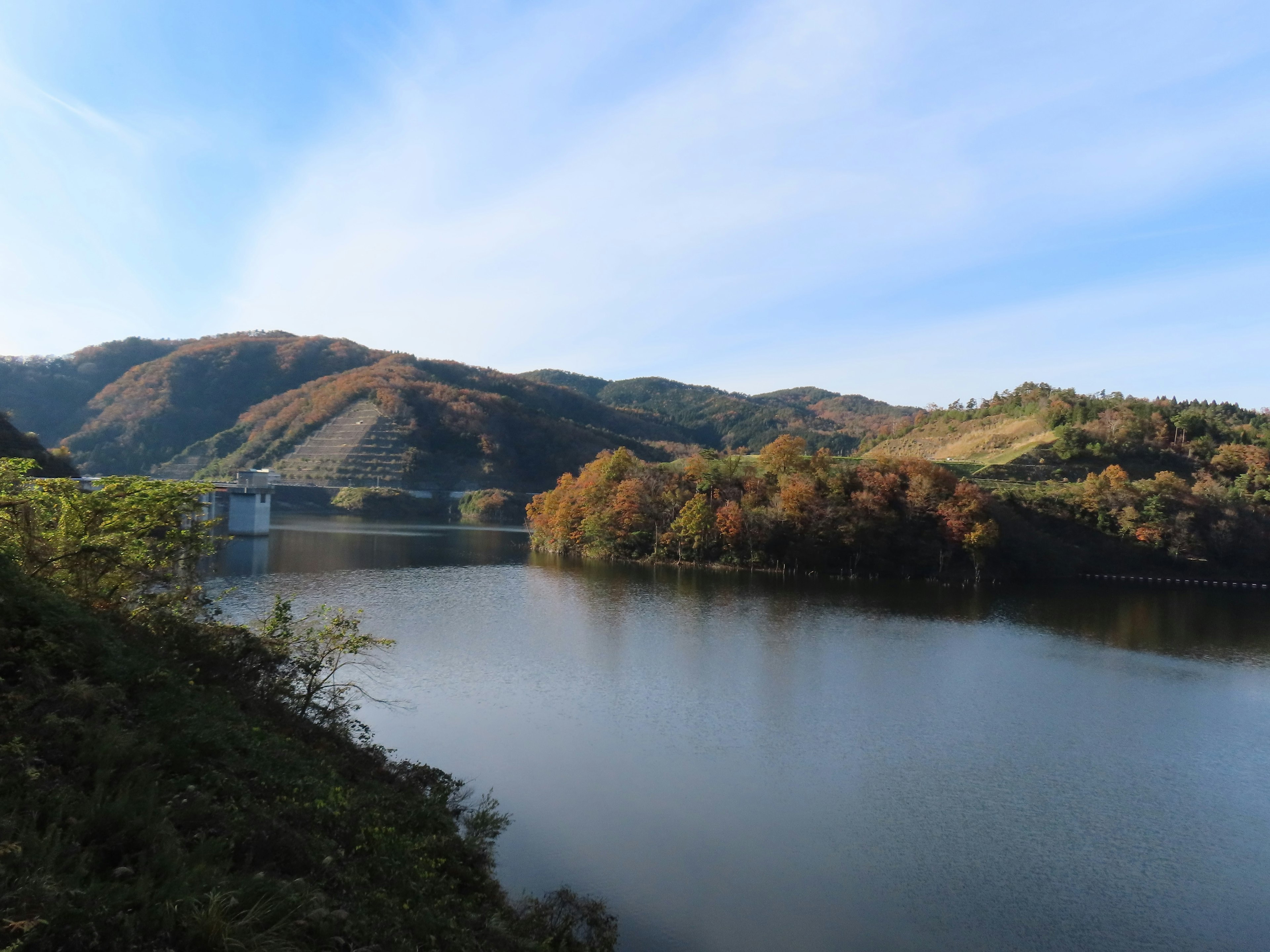 Vue pittoresque d'un lac entouré de feuillage d'automne et de montagnes