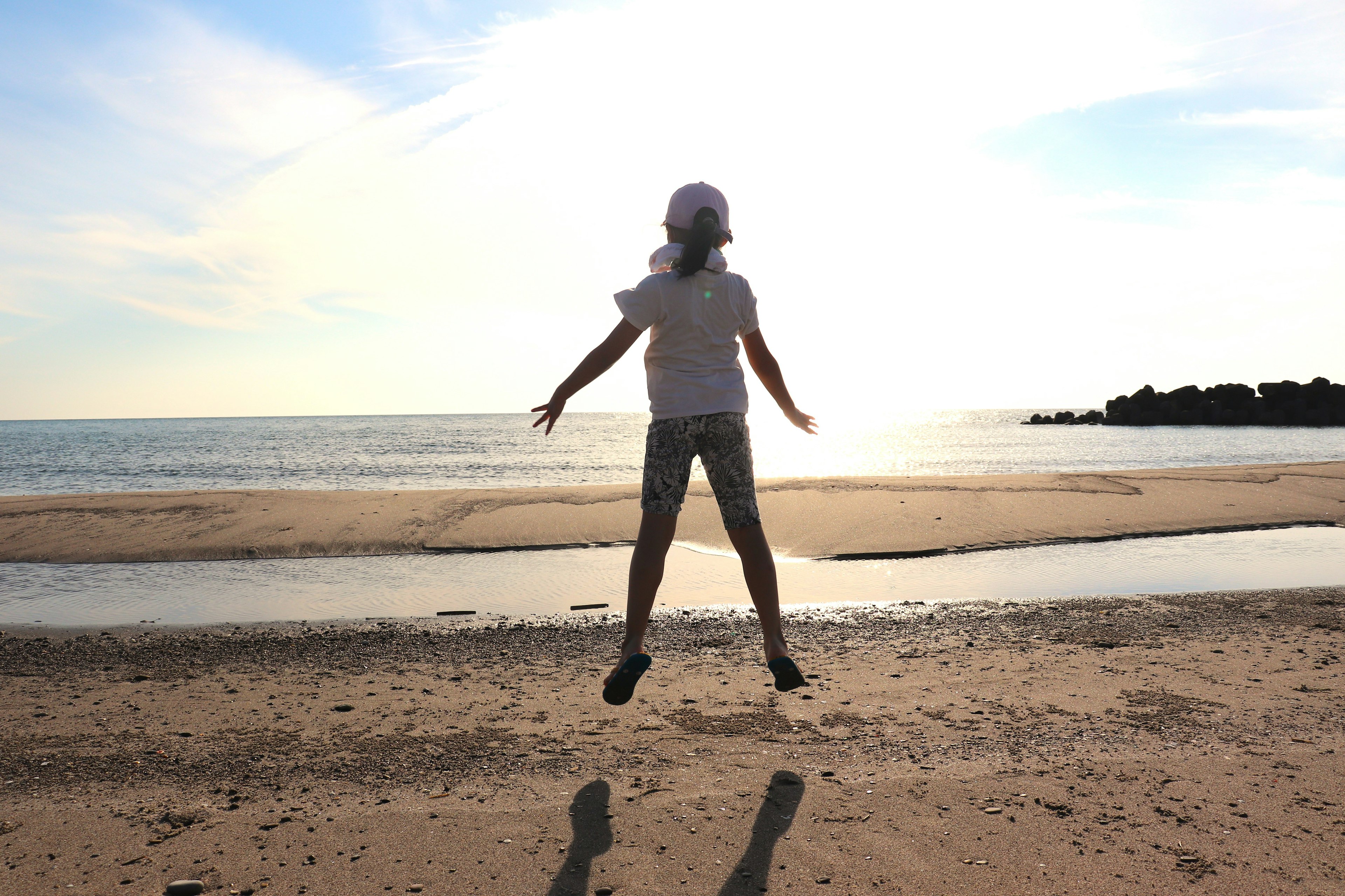 Silhouette eines Kindes, das am Strand springt