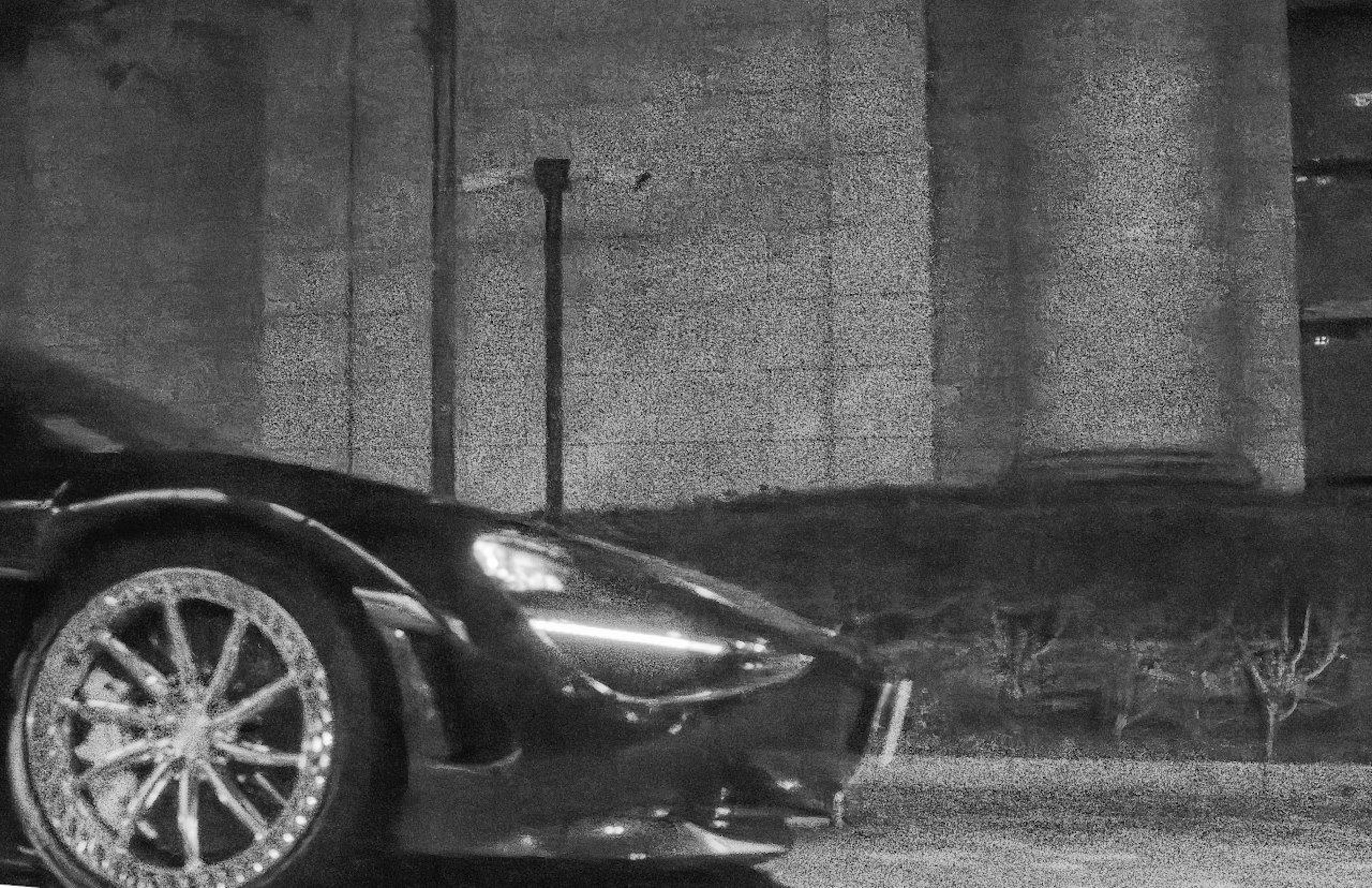 Close-up of a black sports car in a nighttime urban setting