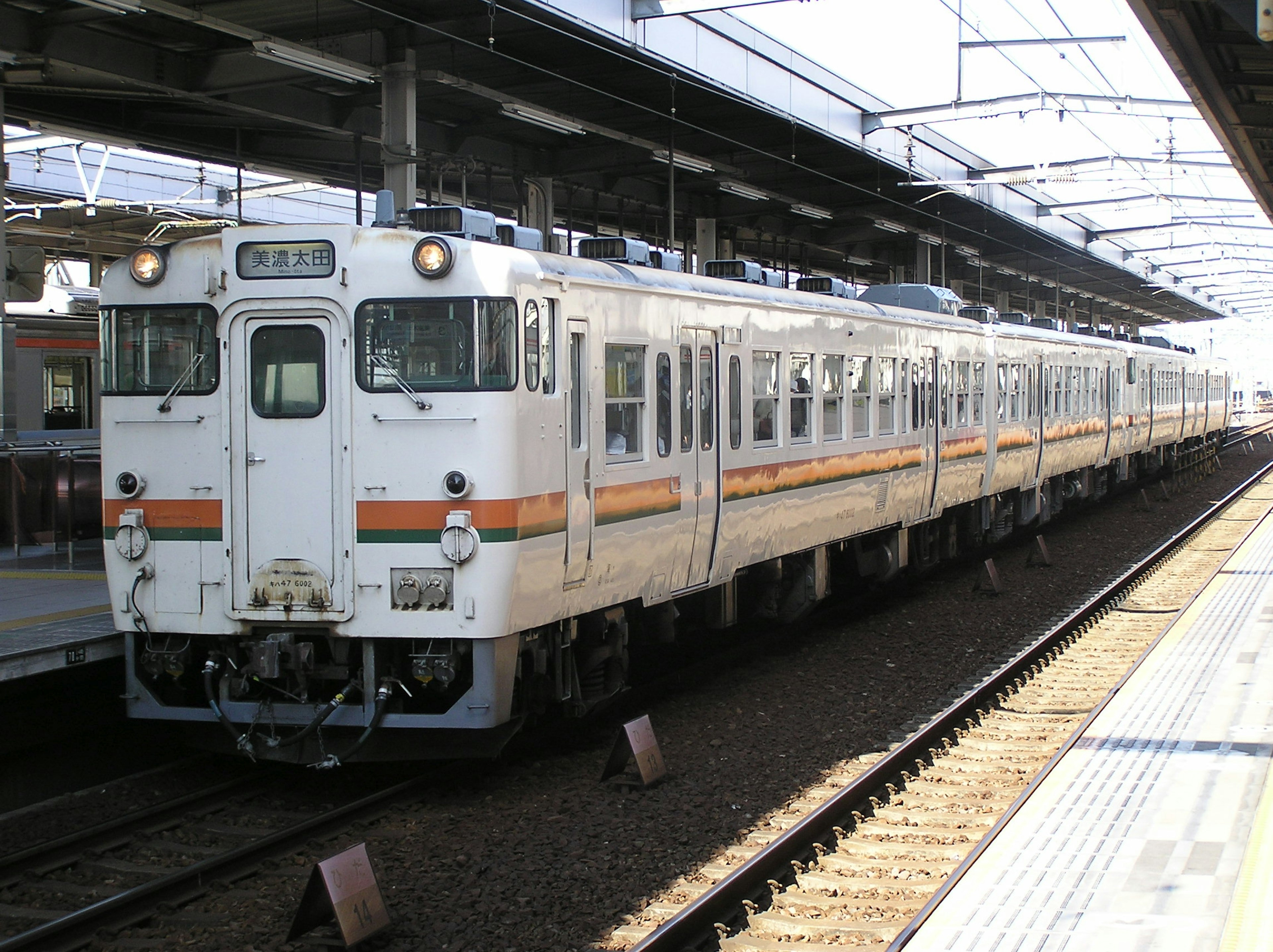 Un treno bianco è fermo a una stazione