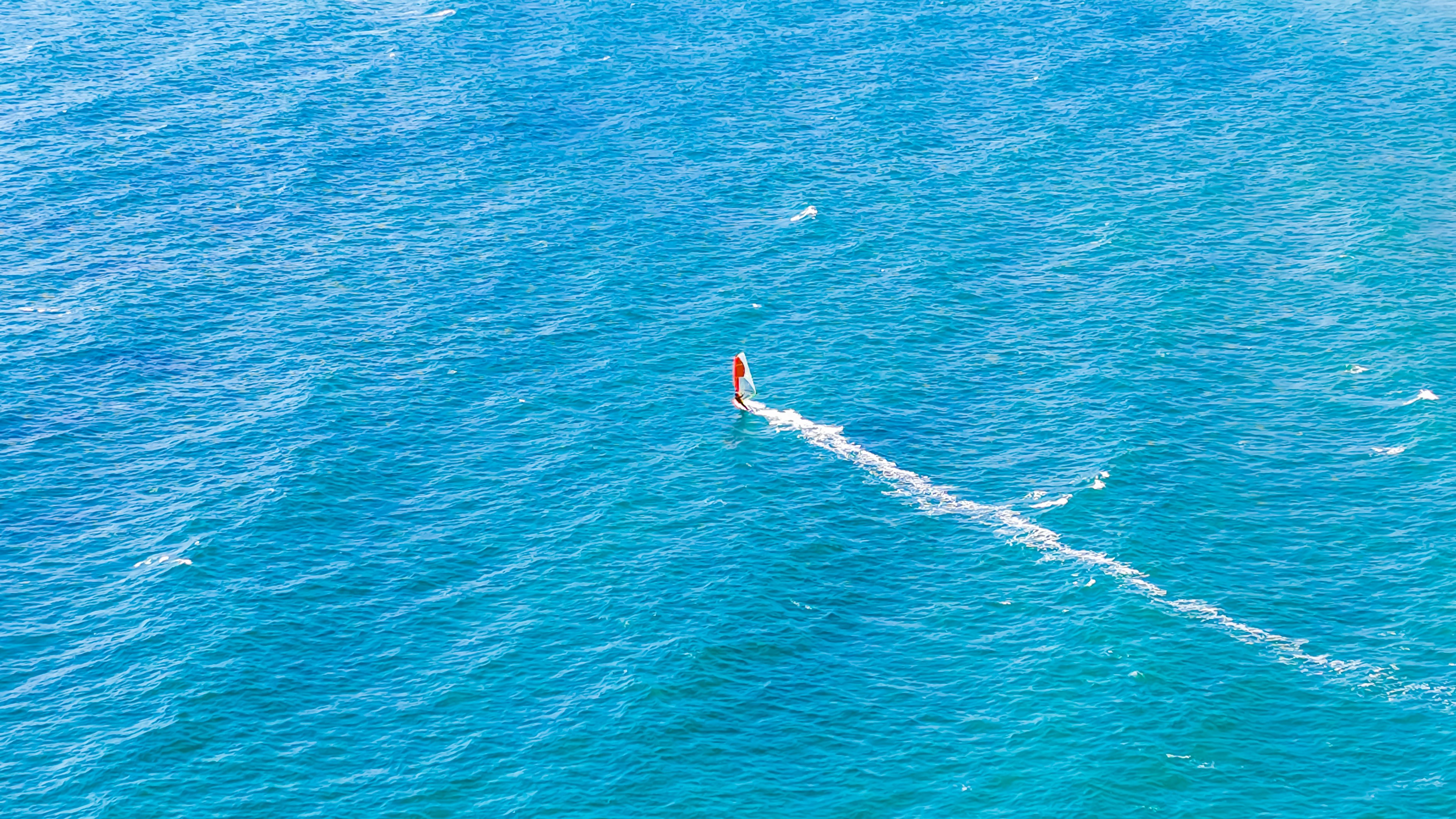 Wind surfista che scivola su un oceano blu