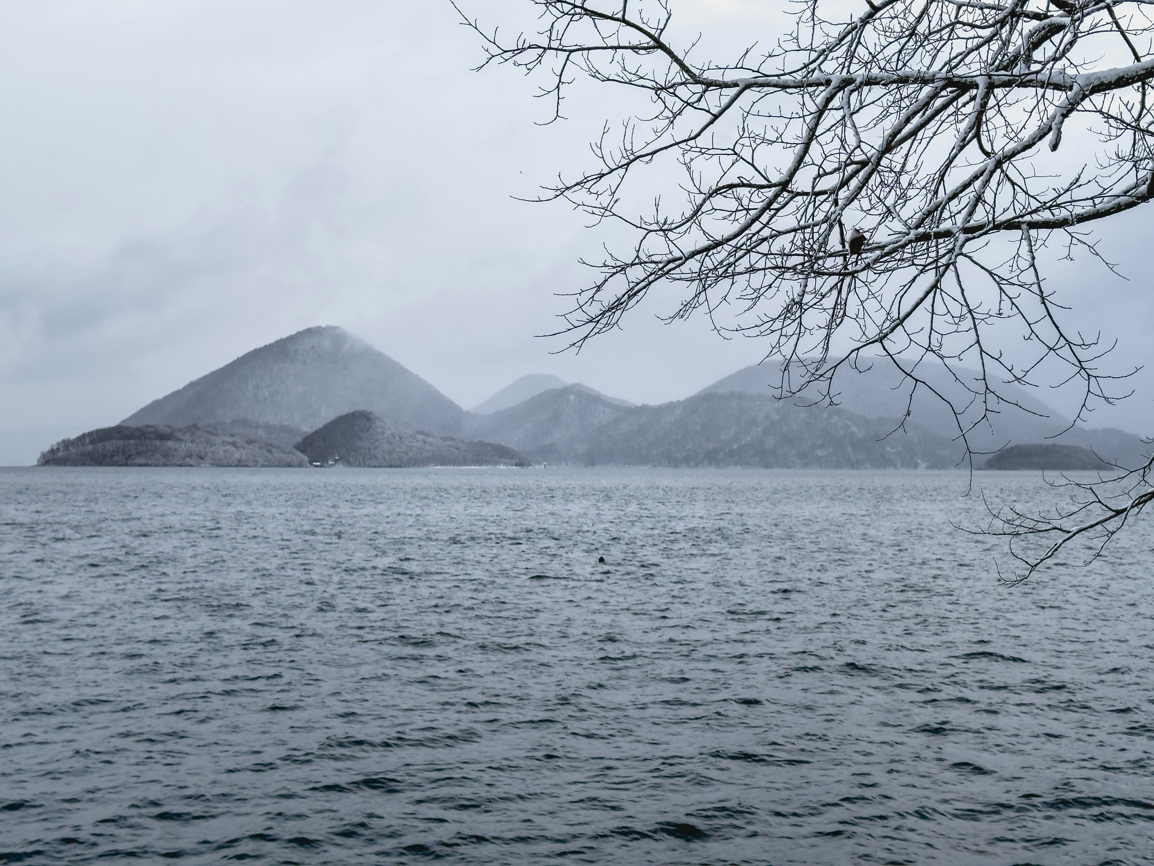 Montañas cubiertas de nieve y superficie de agua tranquila