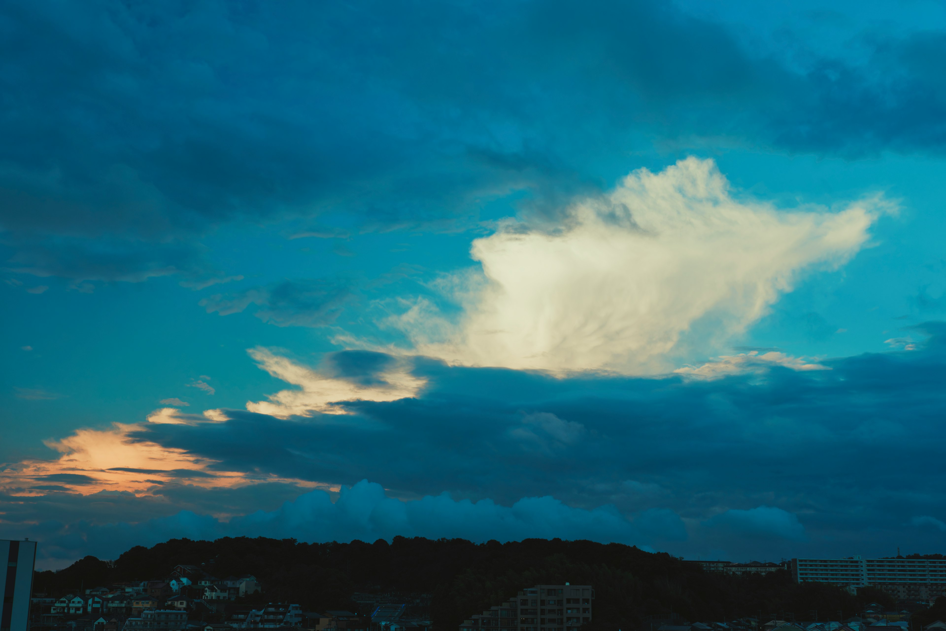 青い空に浮かぶ白い雲と夕焼けの光