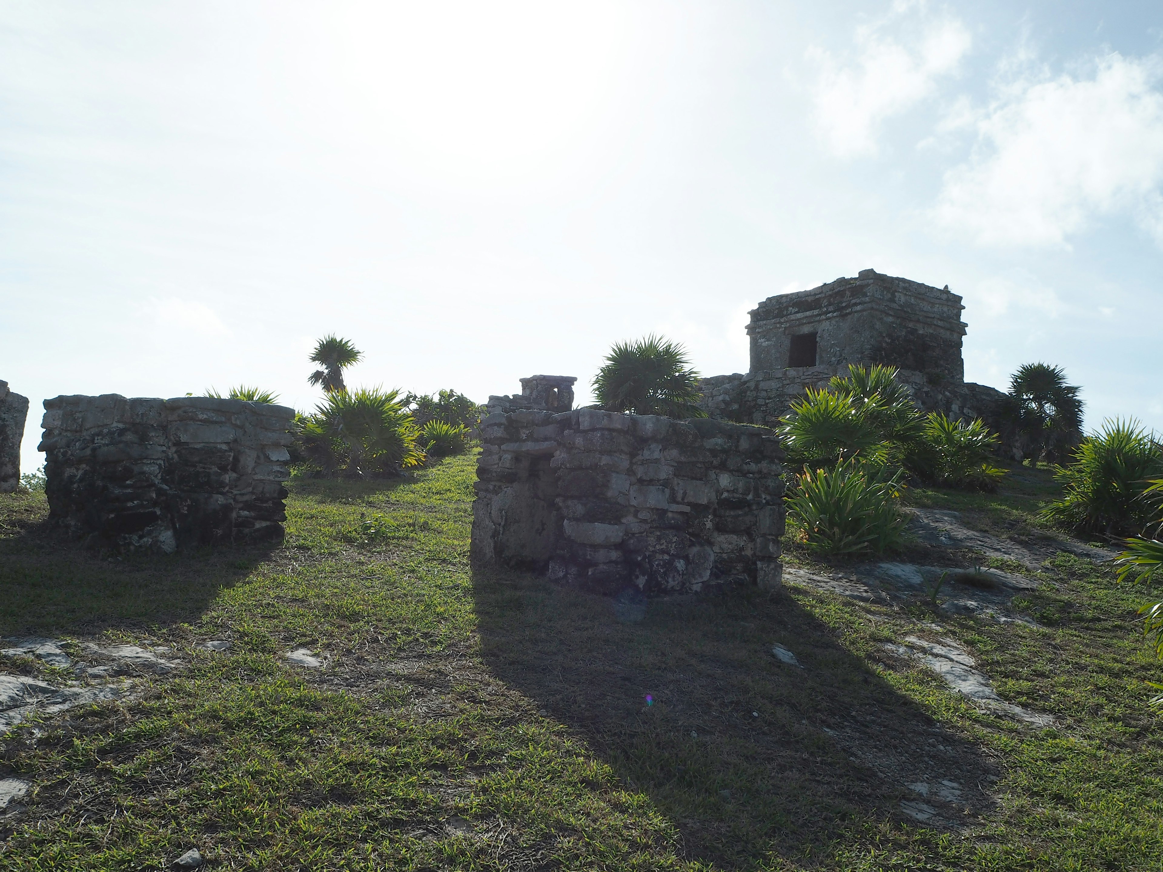 Ruinas antiguas esparcidas en una colina verde bajo un cielo azul