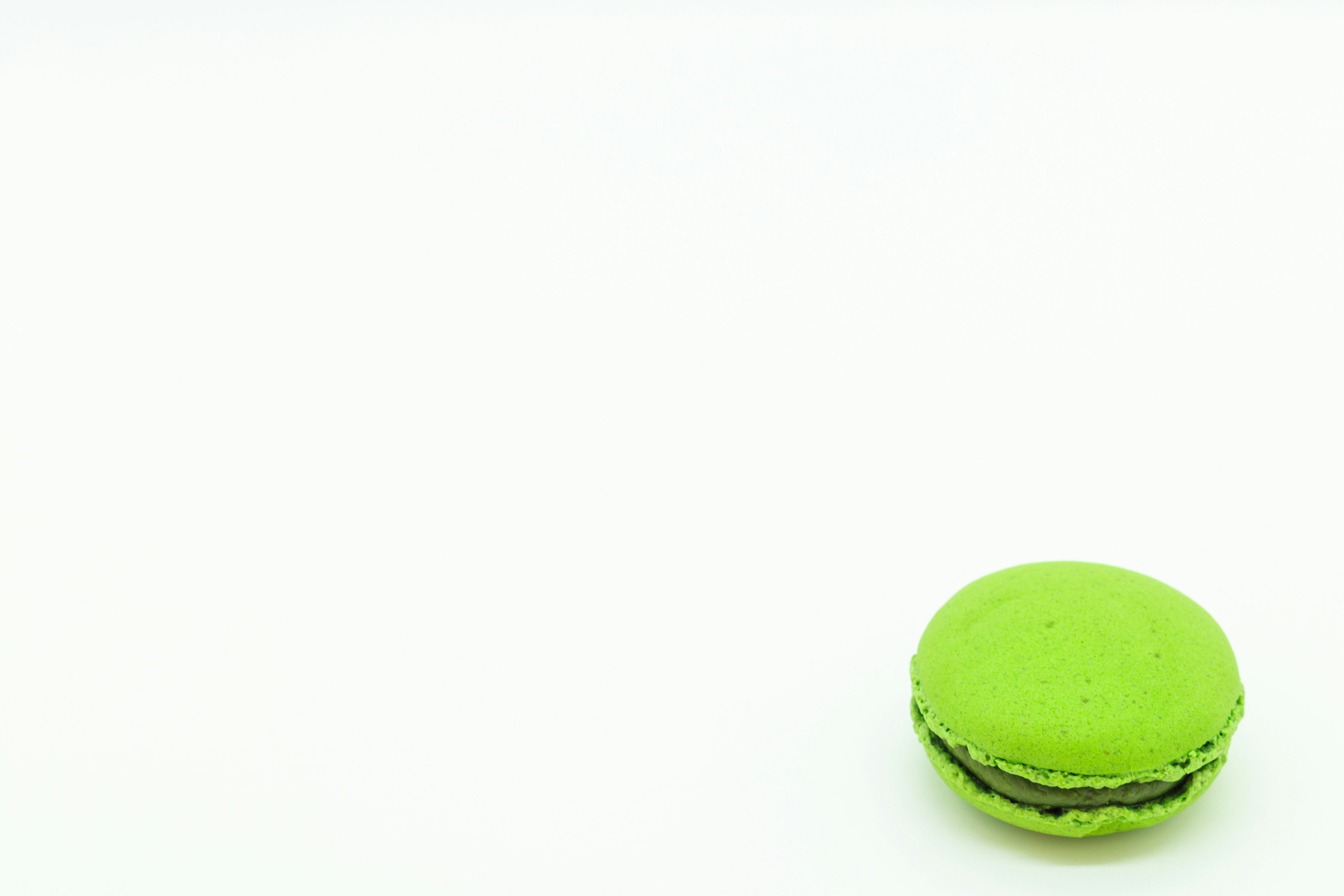 Macaron hijau diletakkan di atas latar belakang putih