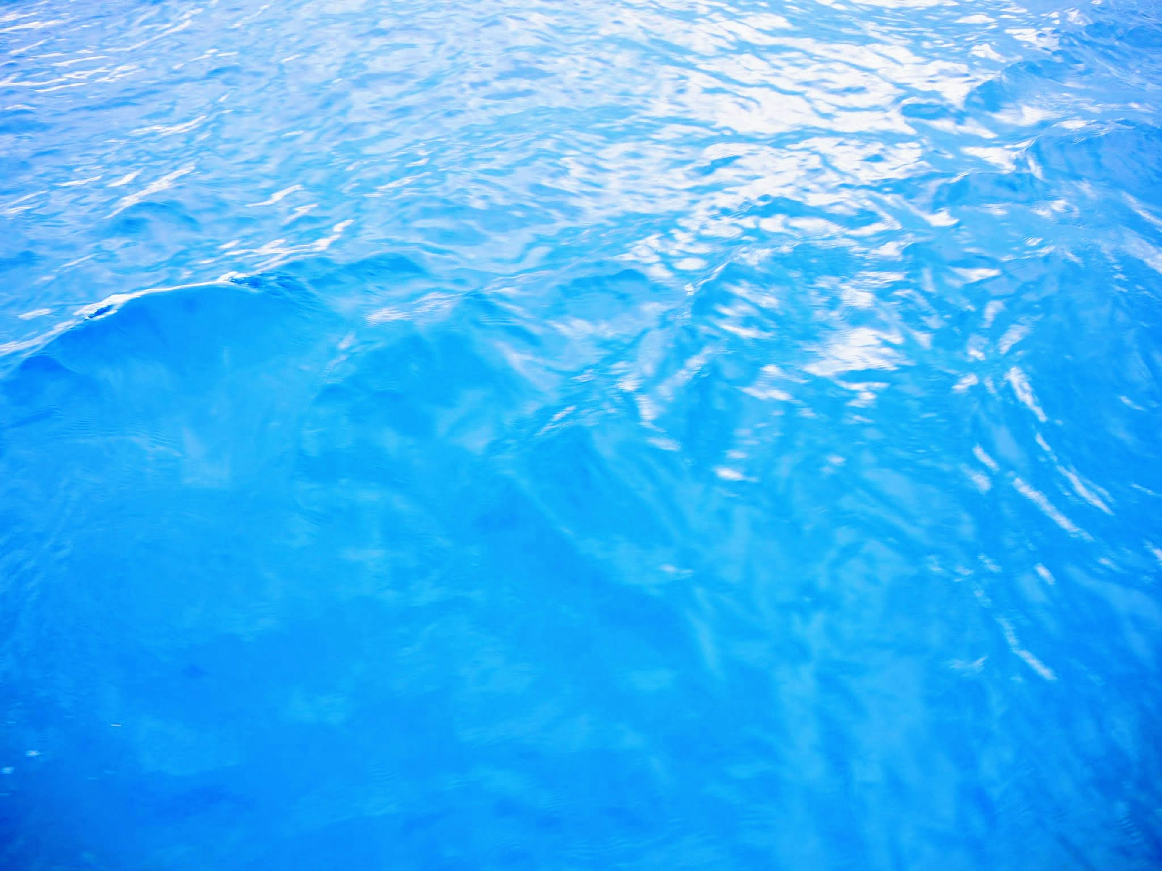 Superficie de agua azul ondulante con reflejos