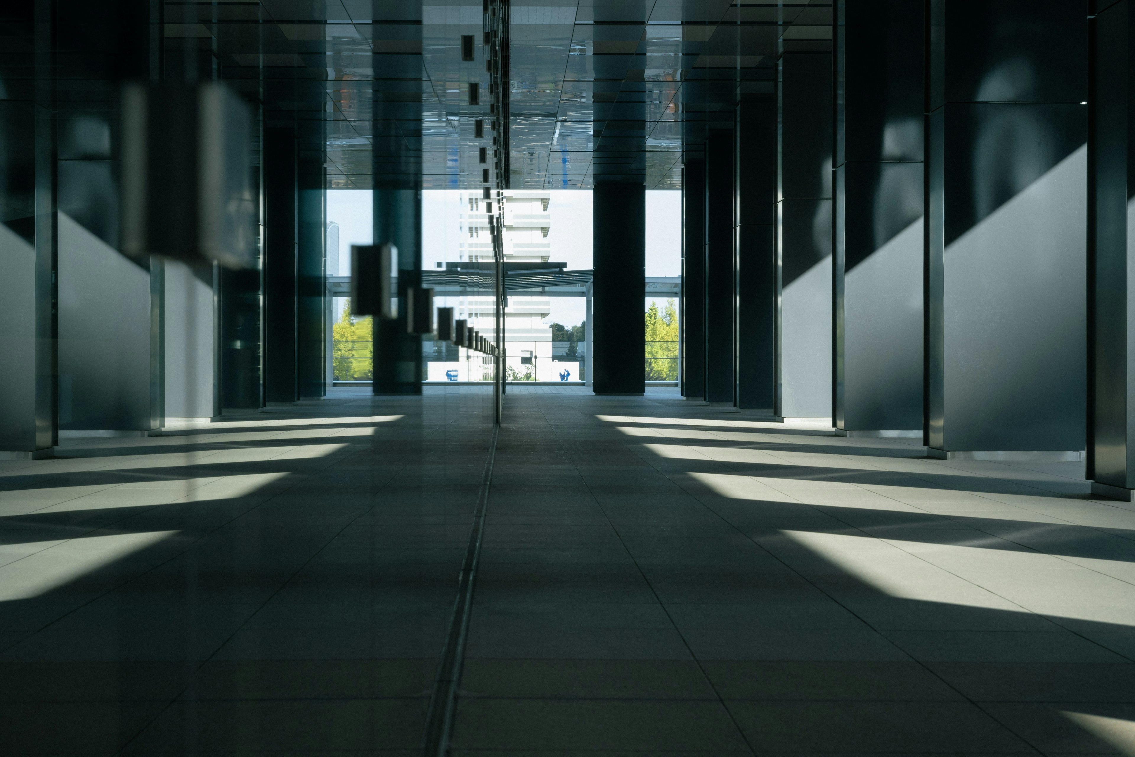 Interior de un edificio moderno con pasillo y sombras de luz en el suelo