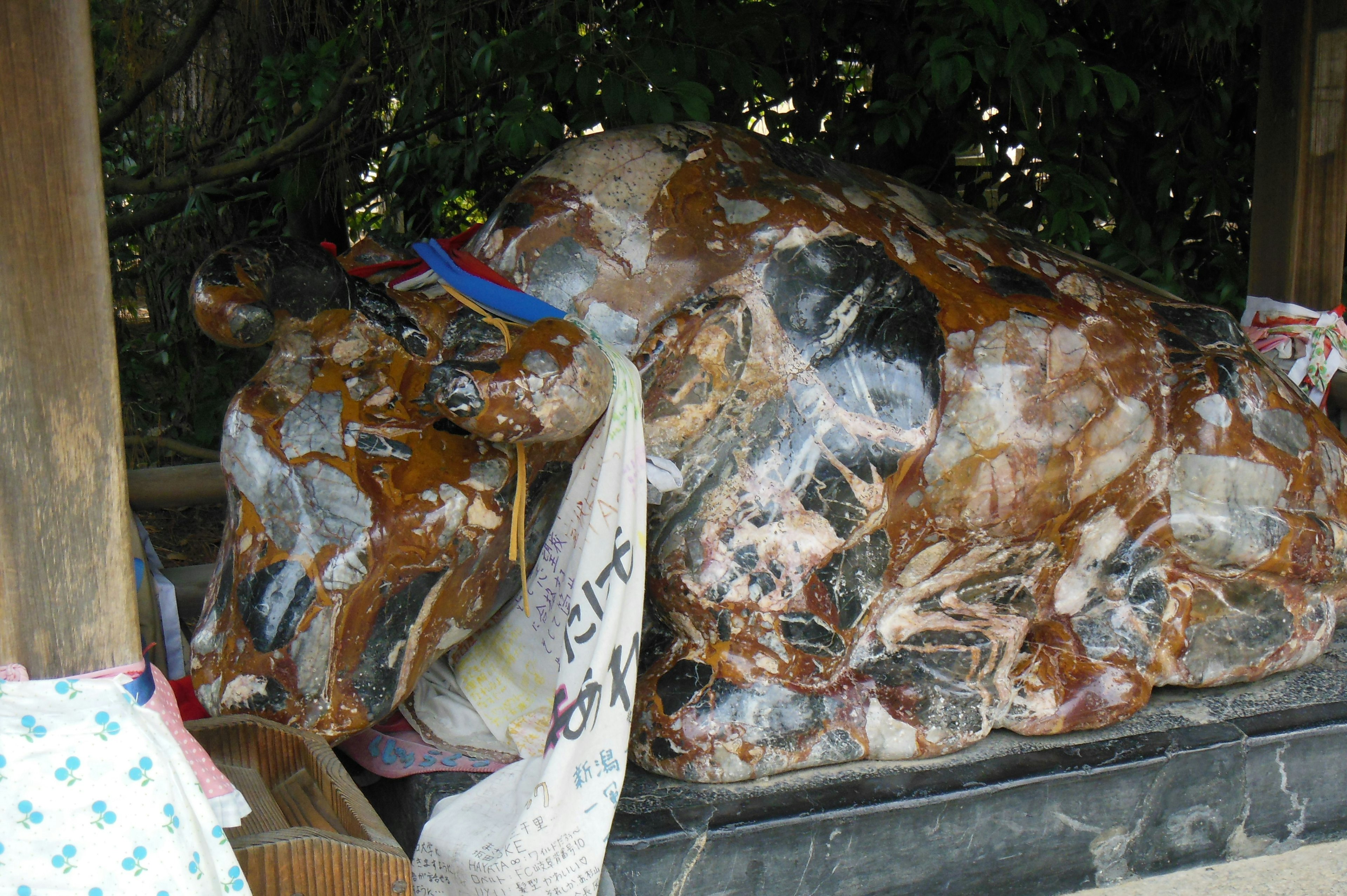 A large brown cow statue wrapped in transparent plastic