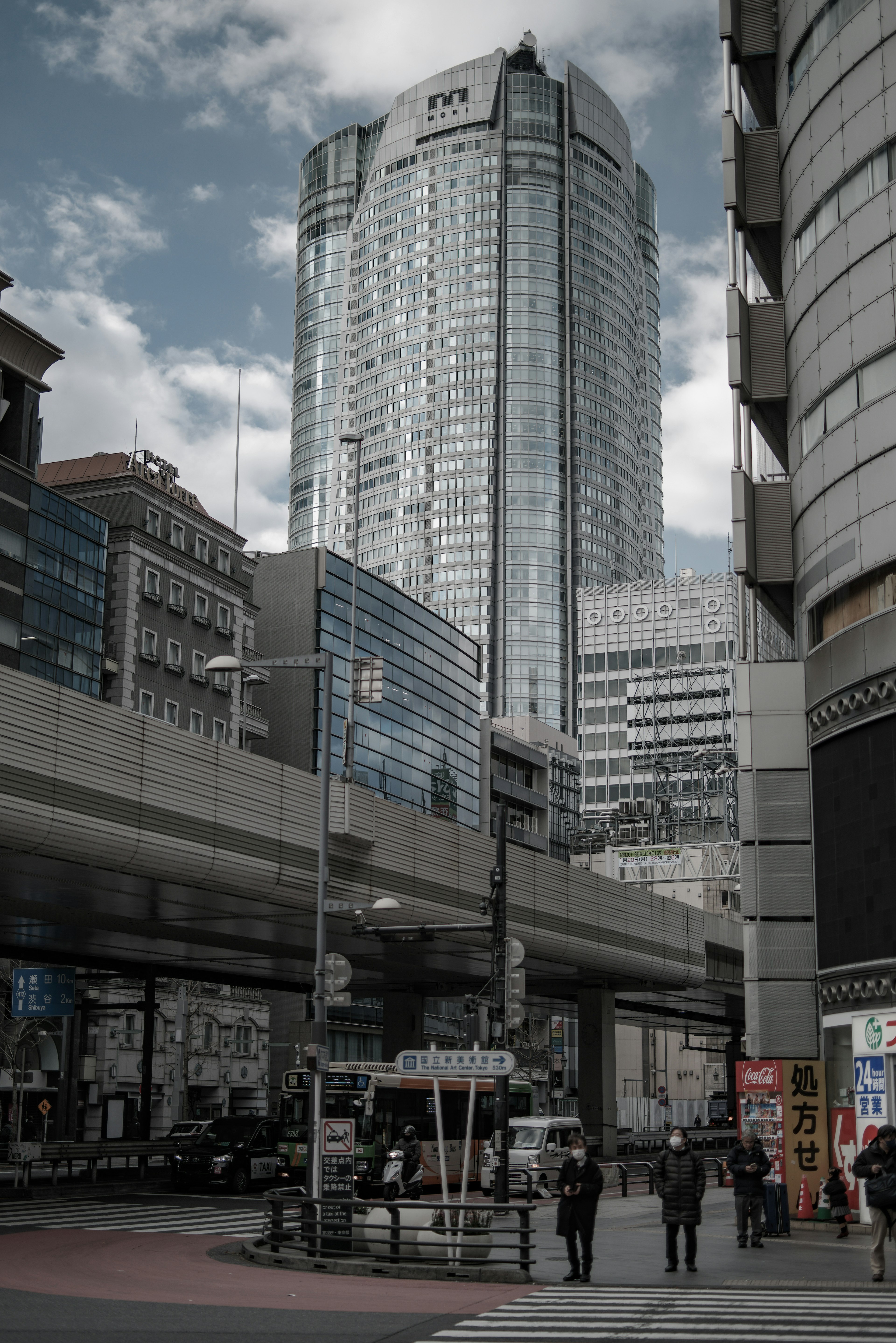 高層ビルと交差点を背景に歩く人々の風景