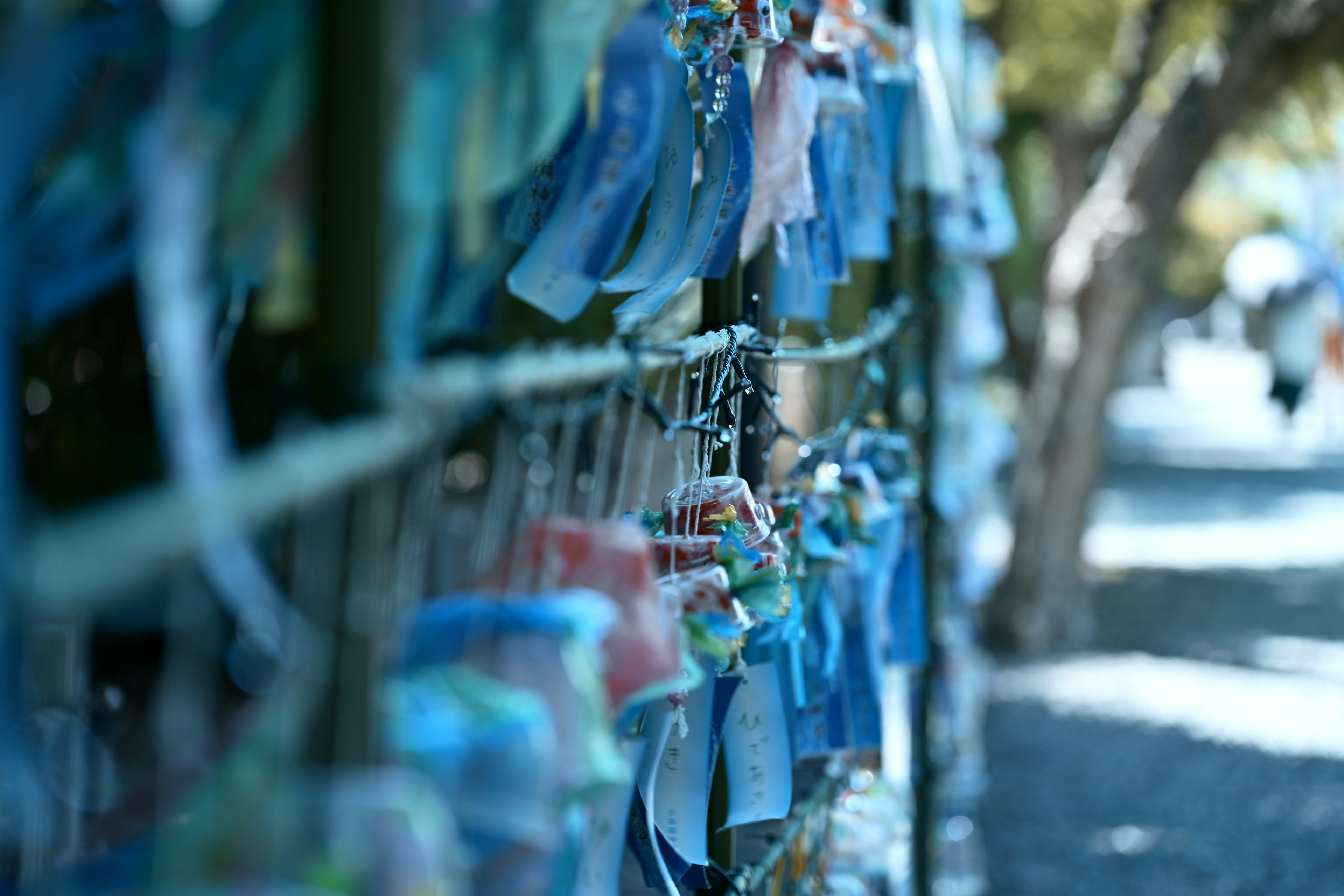 A serene scene with blue and white wind chimes hanging in a row creating a peaceful atmosphere