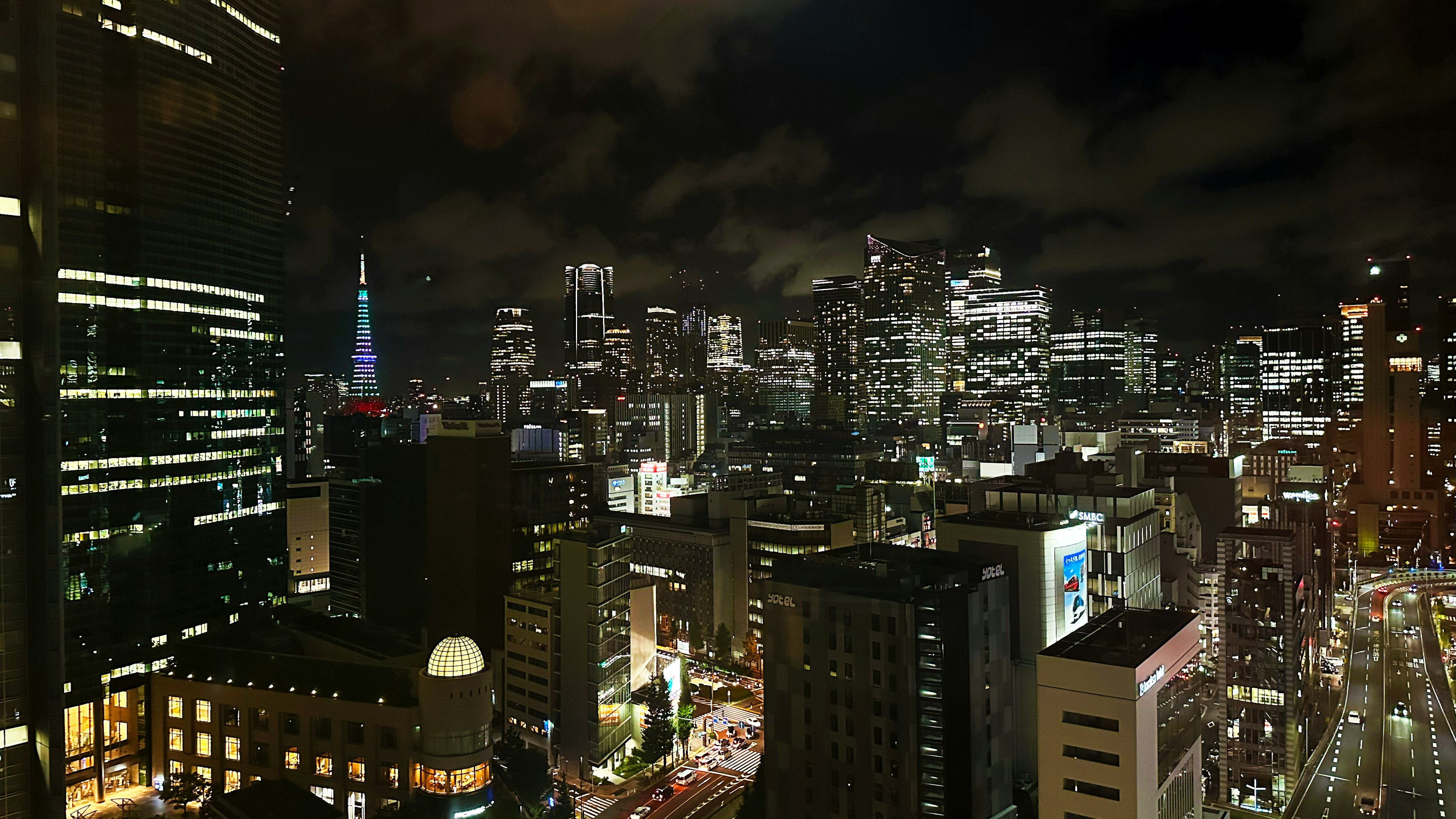 Pemandangan malam Tokyo dengan gedung pencakar langit dan lampu kota terlihat Menara Tokyo