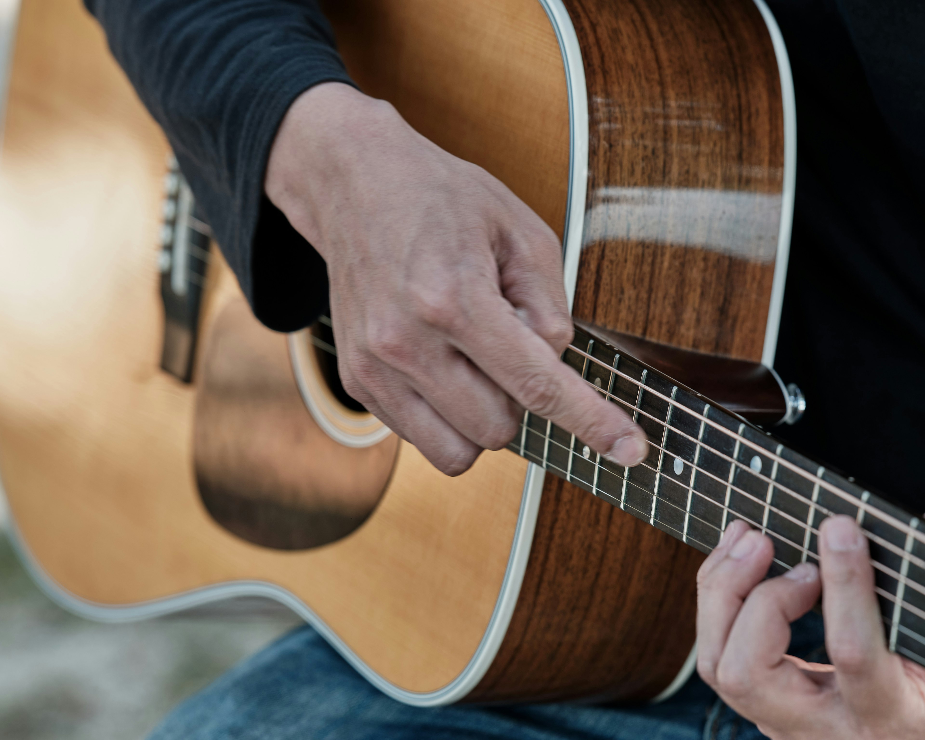 Primo piano di una mano che suona una chitarra acustica