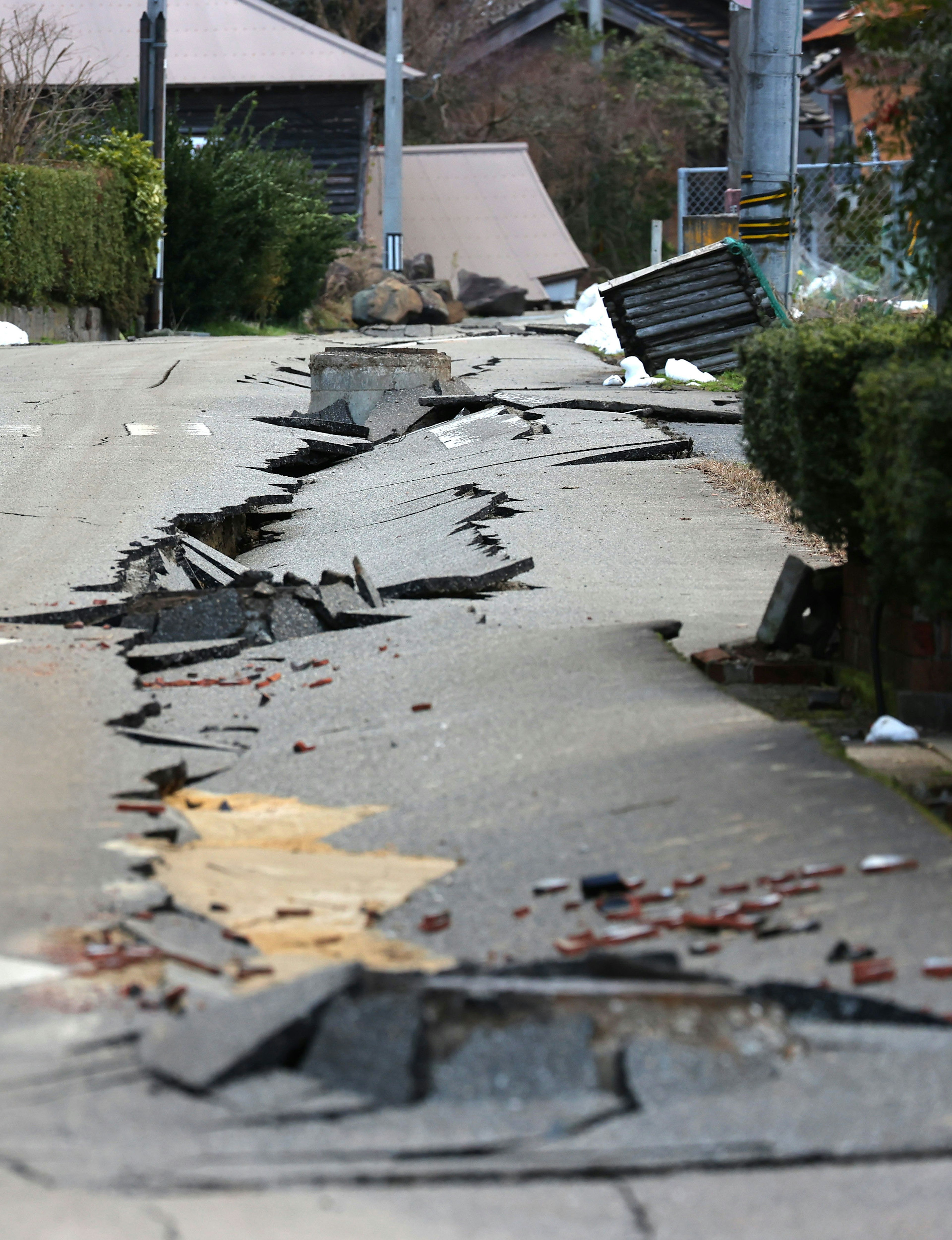 Camino agrietado y escombros por daños de un terremoto