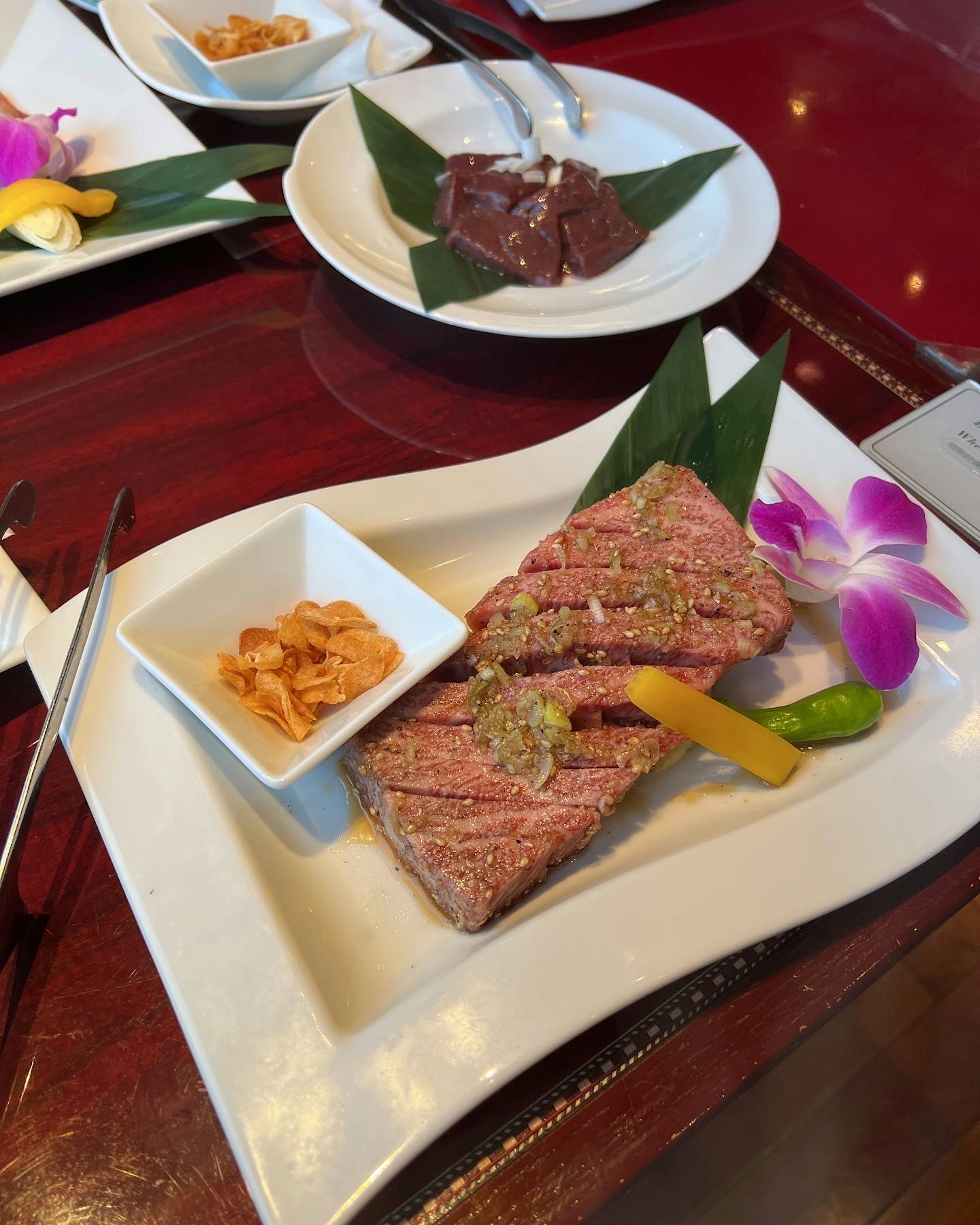 一道美麗呈現的生肉菜餚，配有草藥和花卉裝飾