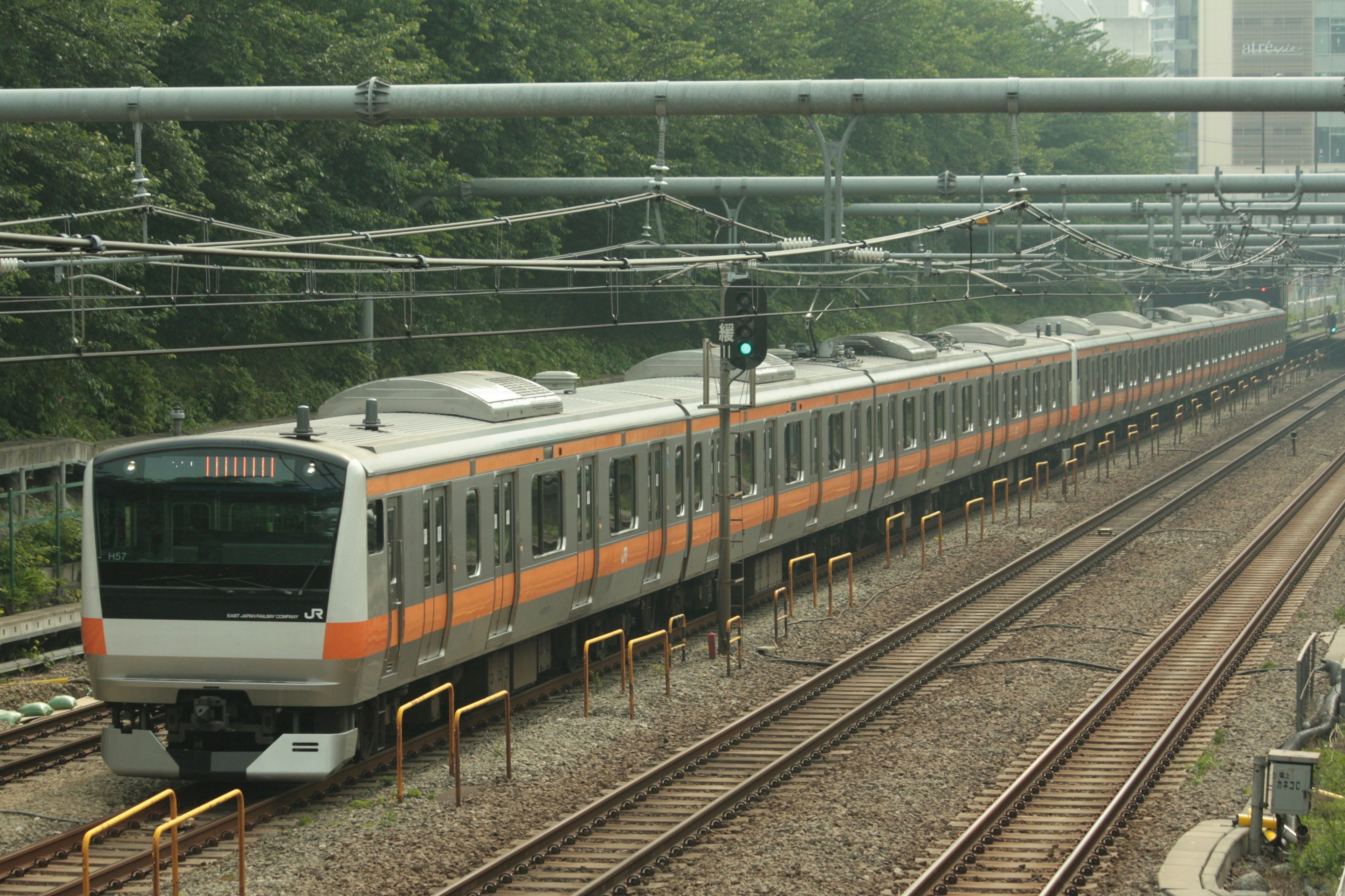 Un train aux couleurs orange et blanche circulant sur les rails