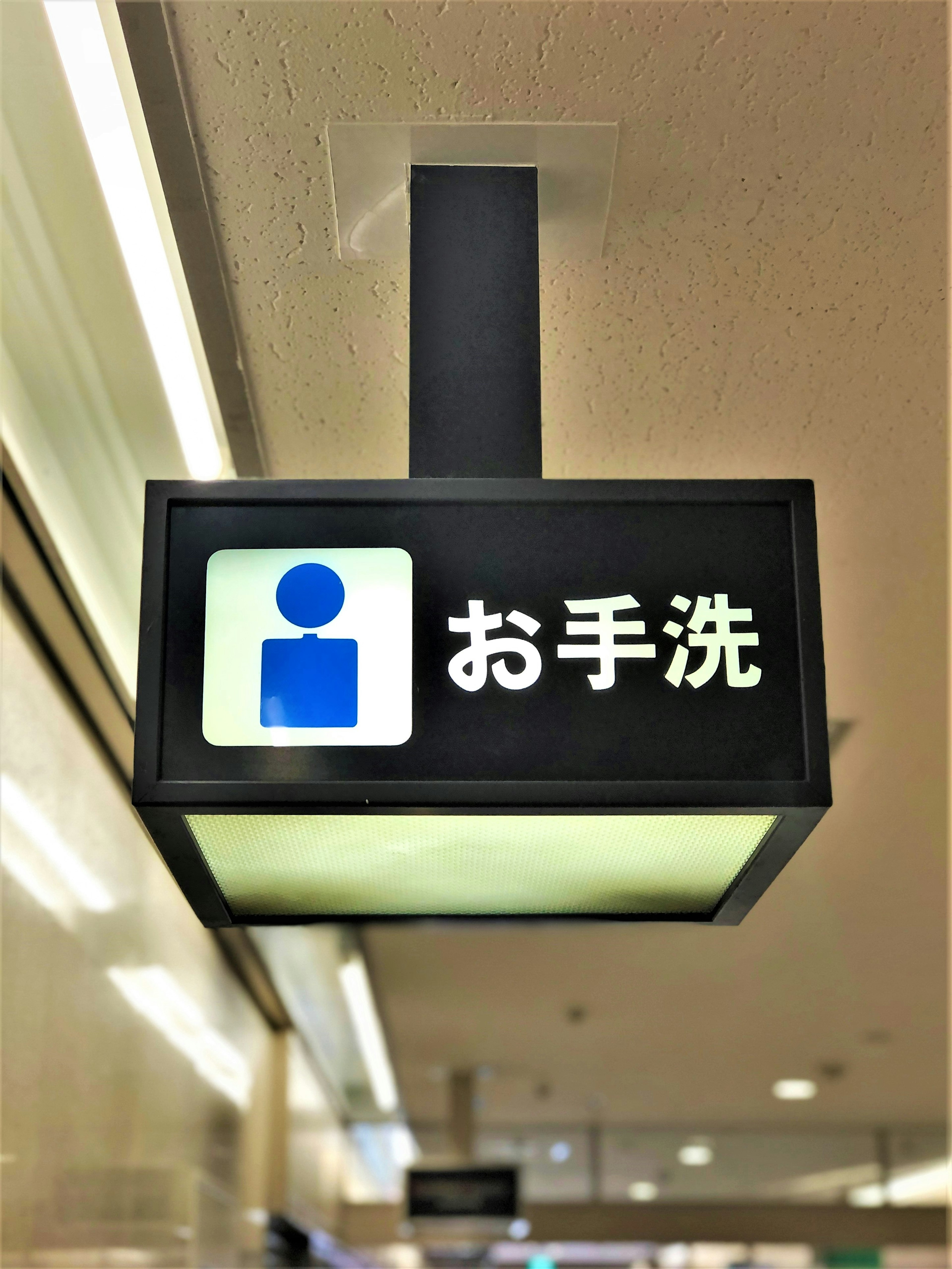 Señal que indica estación de lavado de manos con ícono azul y texto japonés