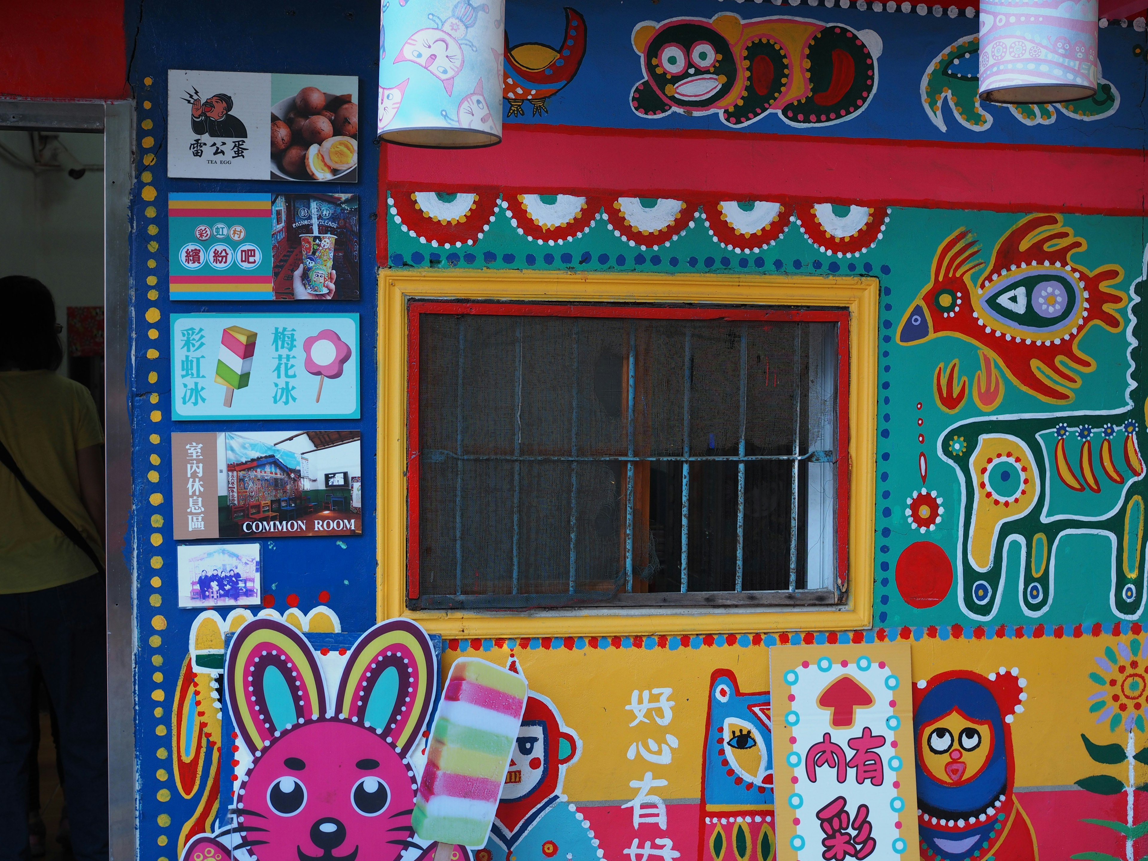 Pared colorida con ilustraciones de animales y señalización en una pequeña cabaña