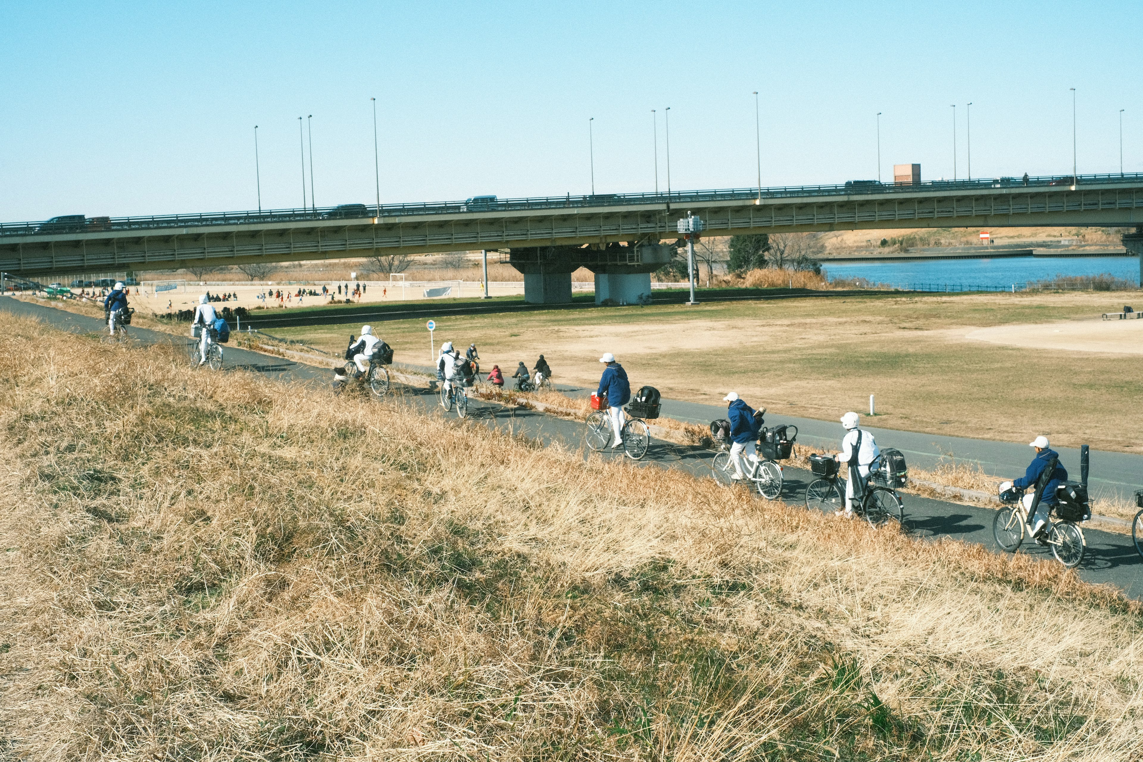 Un groupe de cyclistes roulant le long d'un chemin de cyclisme au bord de la rivière