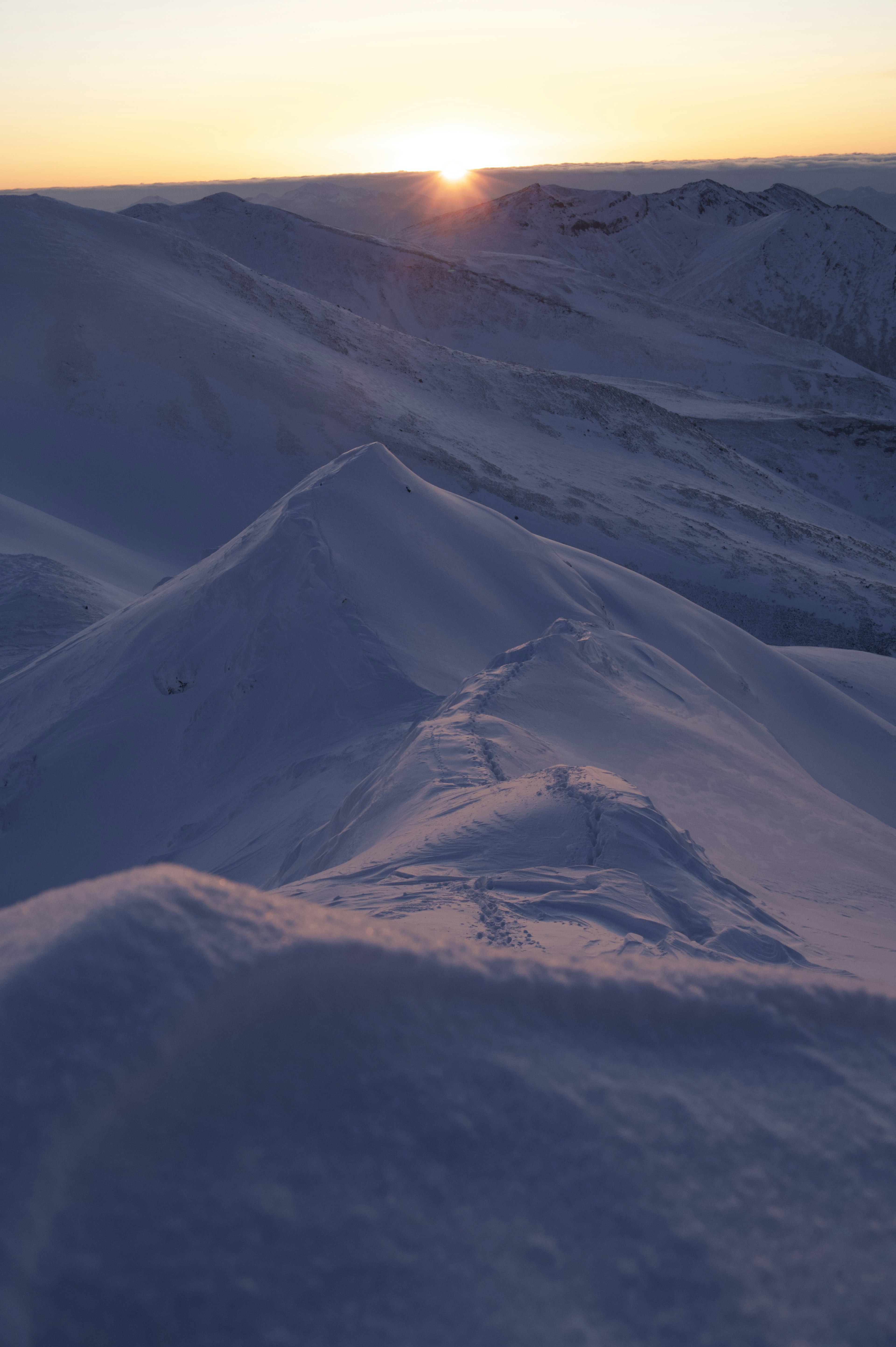 雪に覆われた山々と夕日の景色