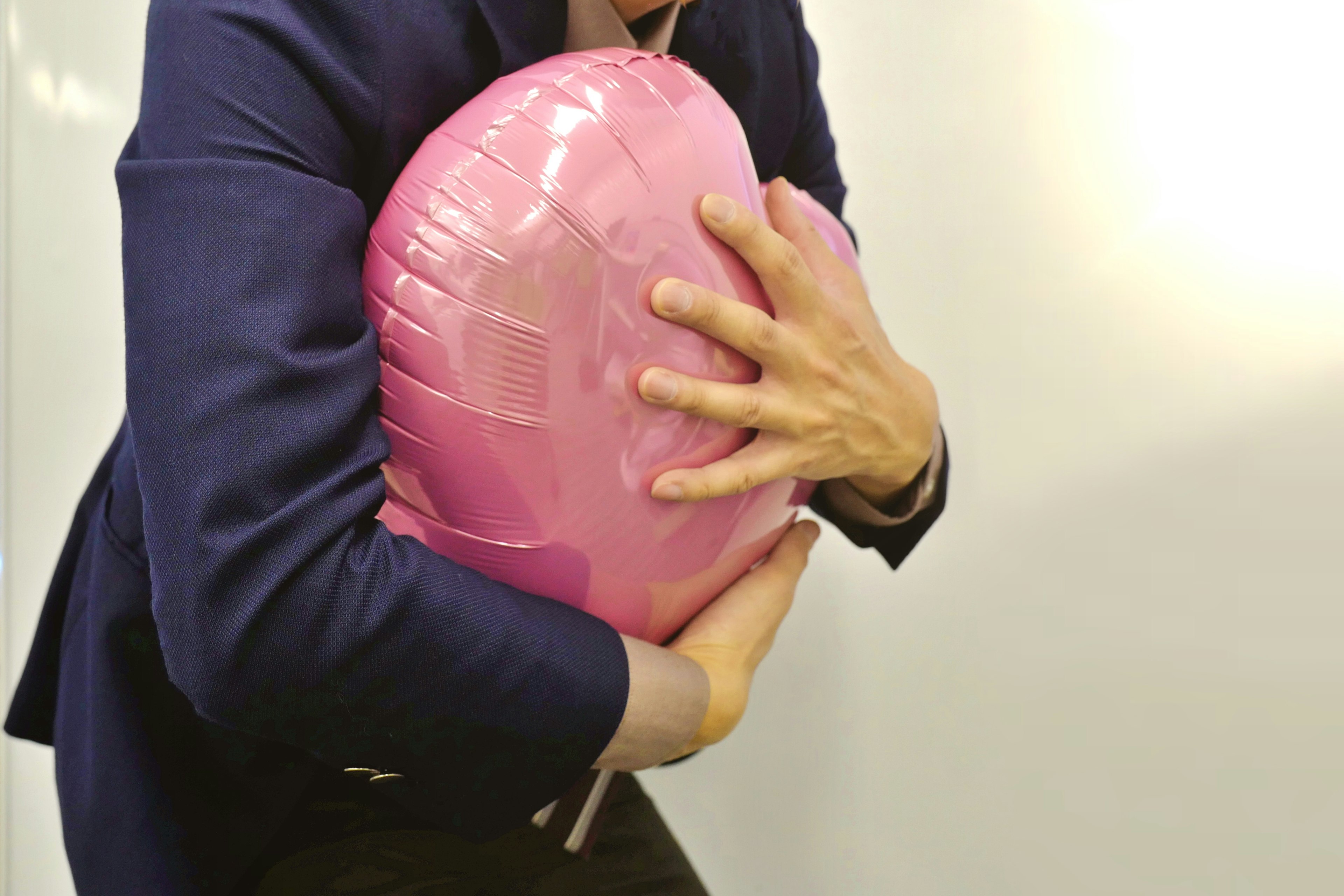 Primer plano de una persona abrazando una pelota rosa