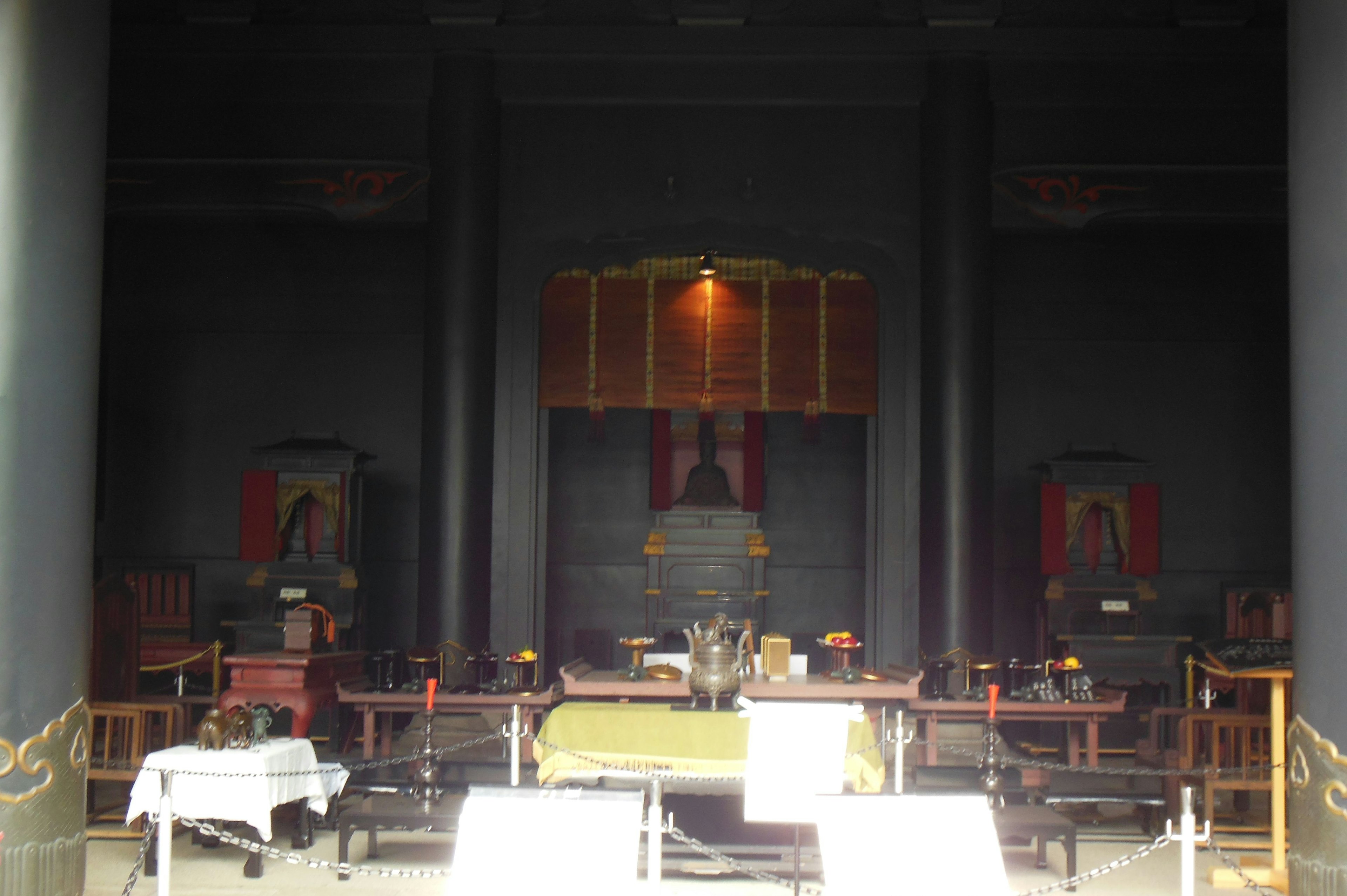 Espace intérieur traditionnel chinois entouré de murs sombres avec des tables et des chaises