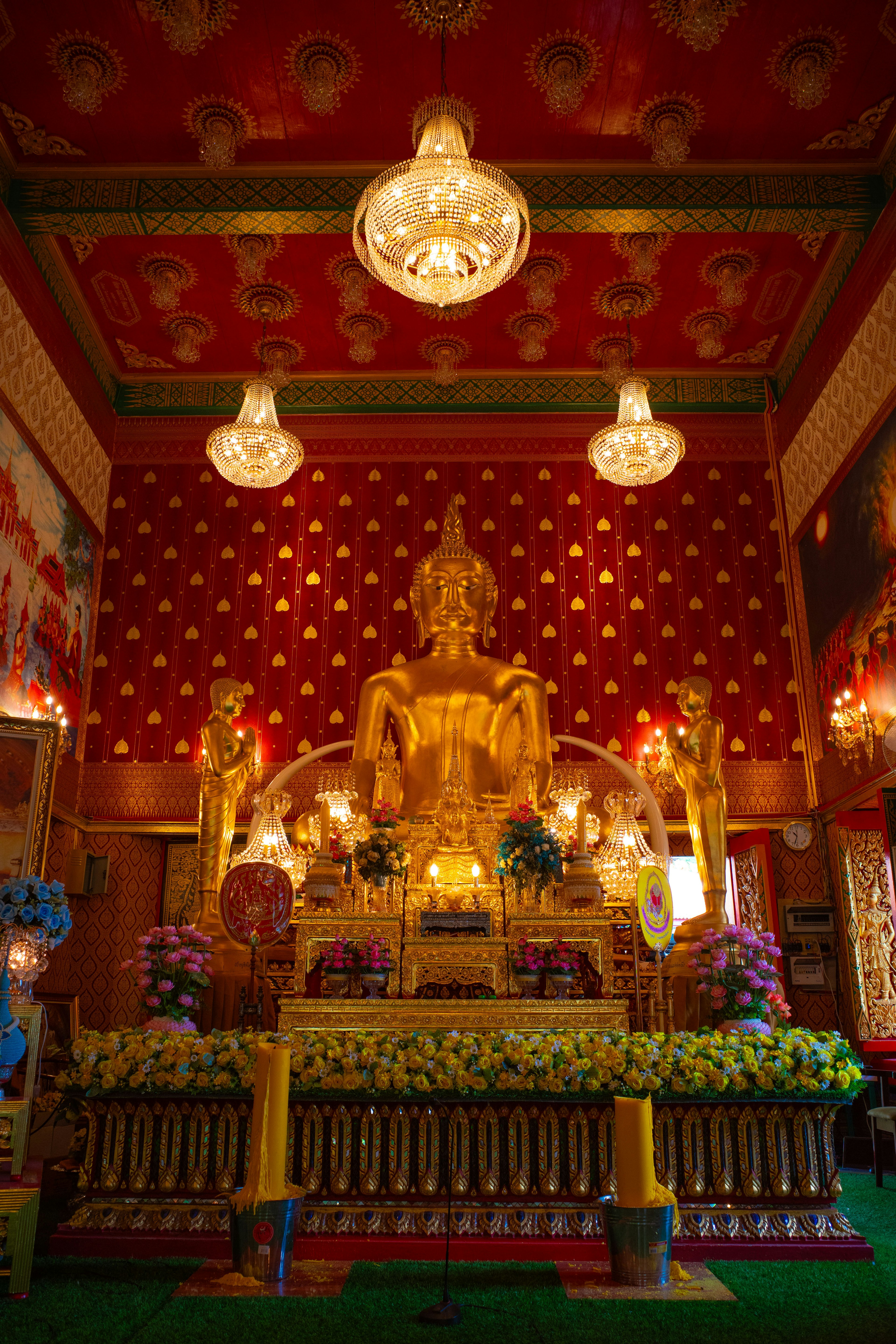 Interior of a vibrant temple featuring a central golden Buddha statue