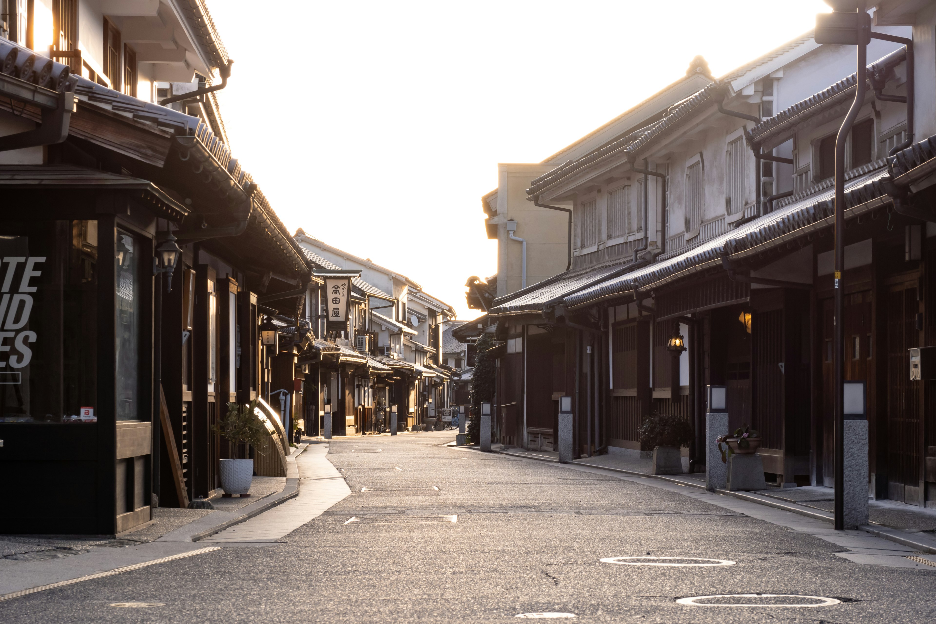 静かな日本の街並み、古い建物と舗装された道、夕日の柔らかい光