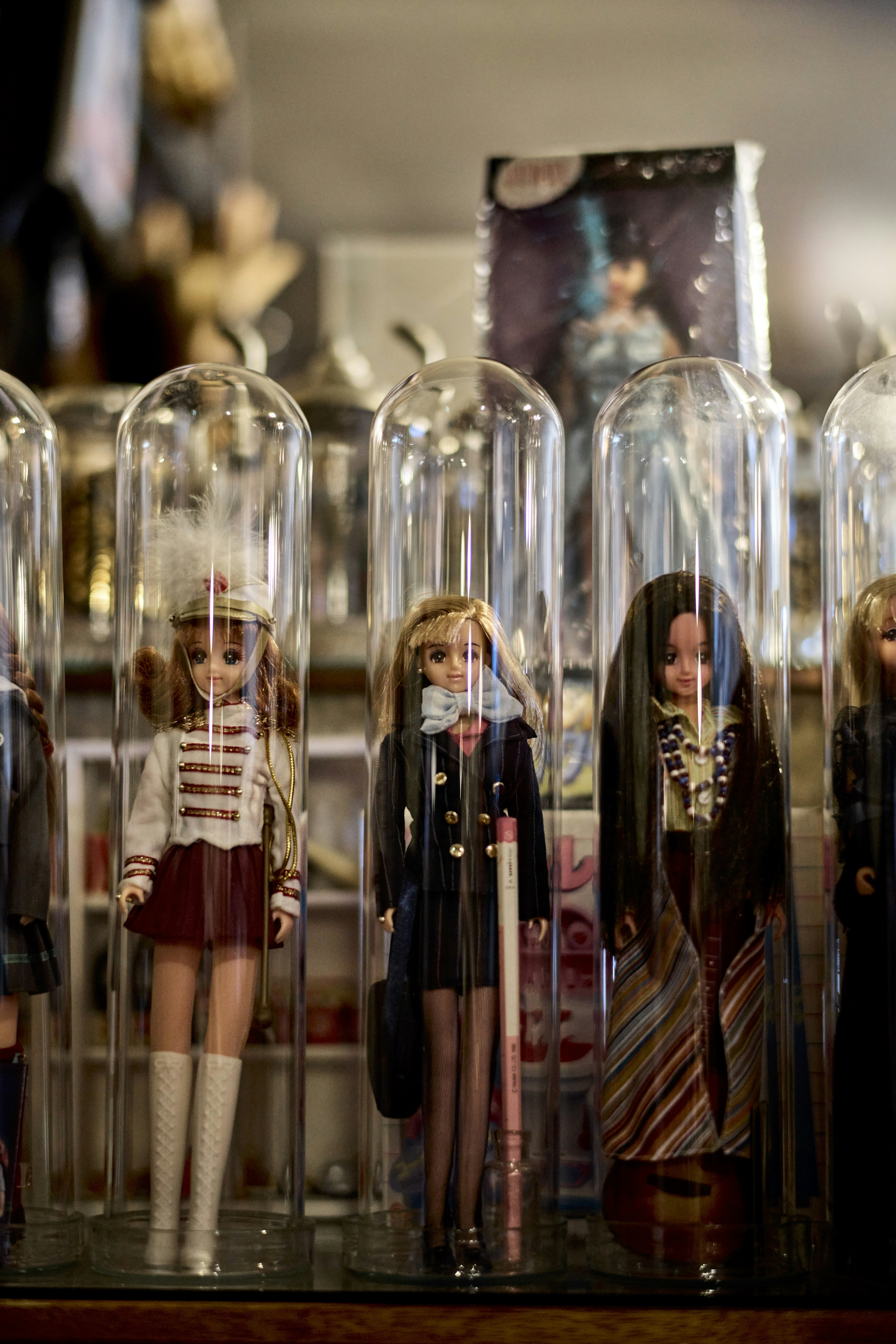 Une vitrine de poupées enfermées dans des cloches en verre dans un magasin