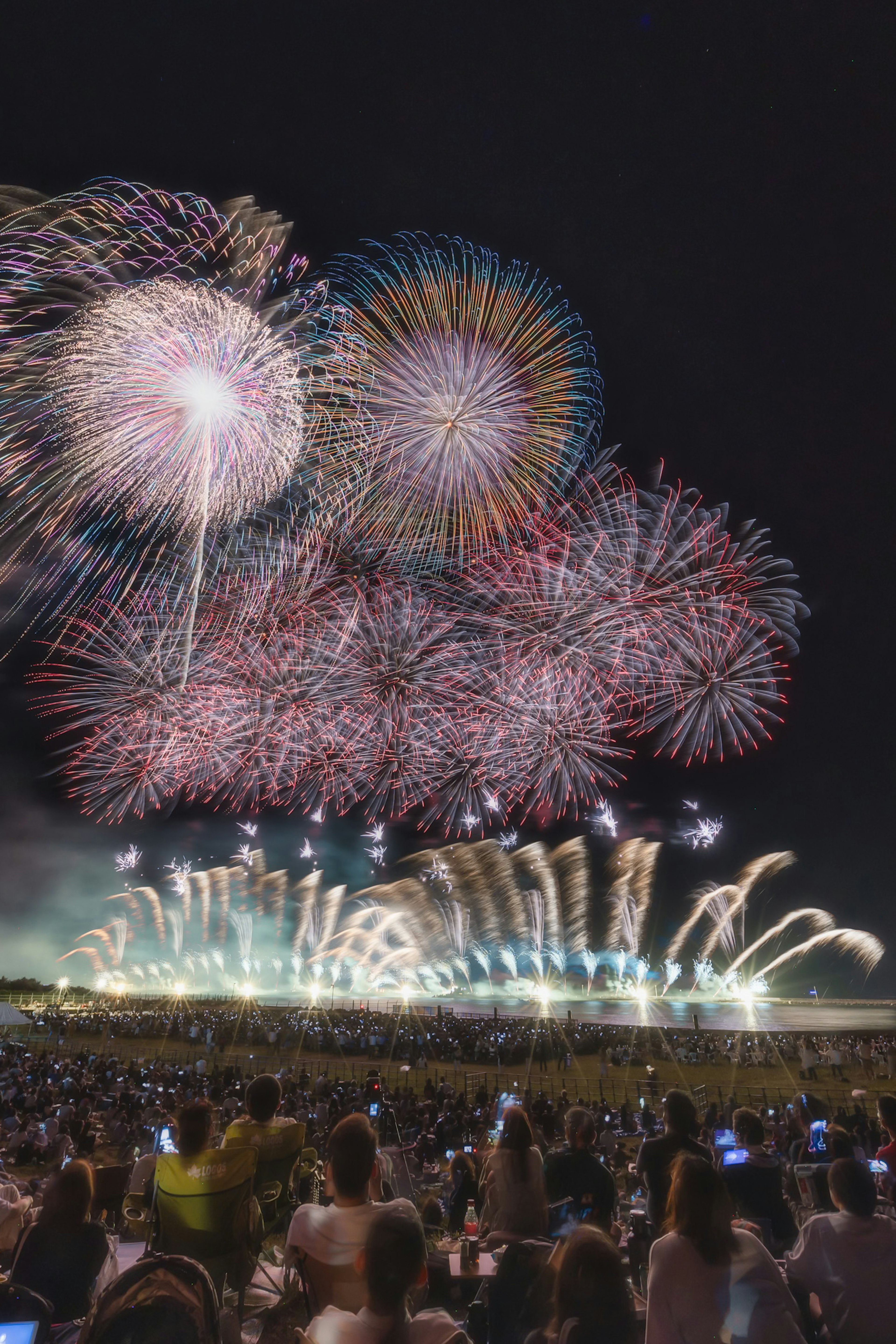 夜空に広がる華やかな花火と観客のシルエット