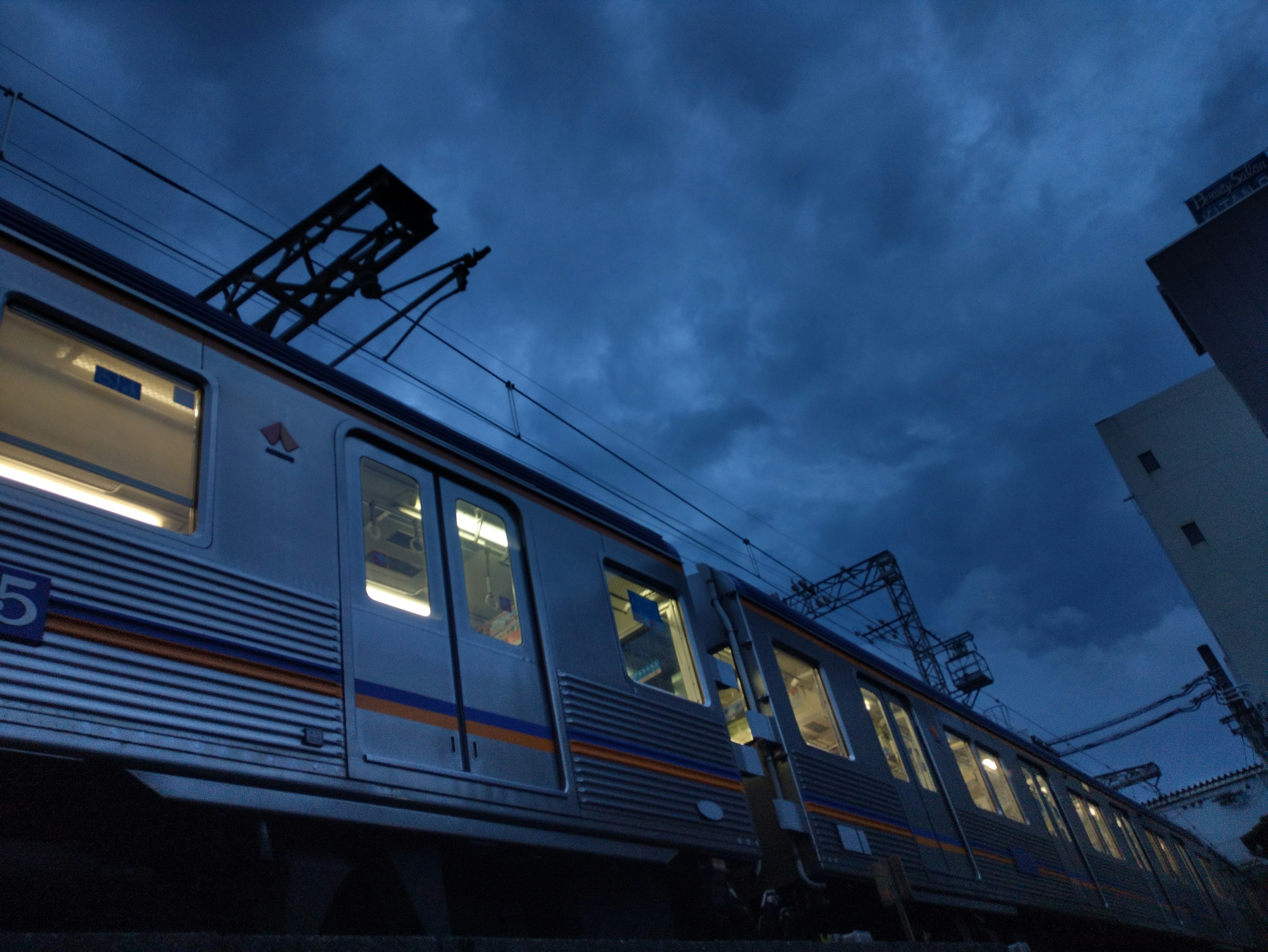 Train passing under a dark sky with illuminated windows