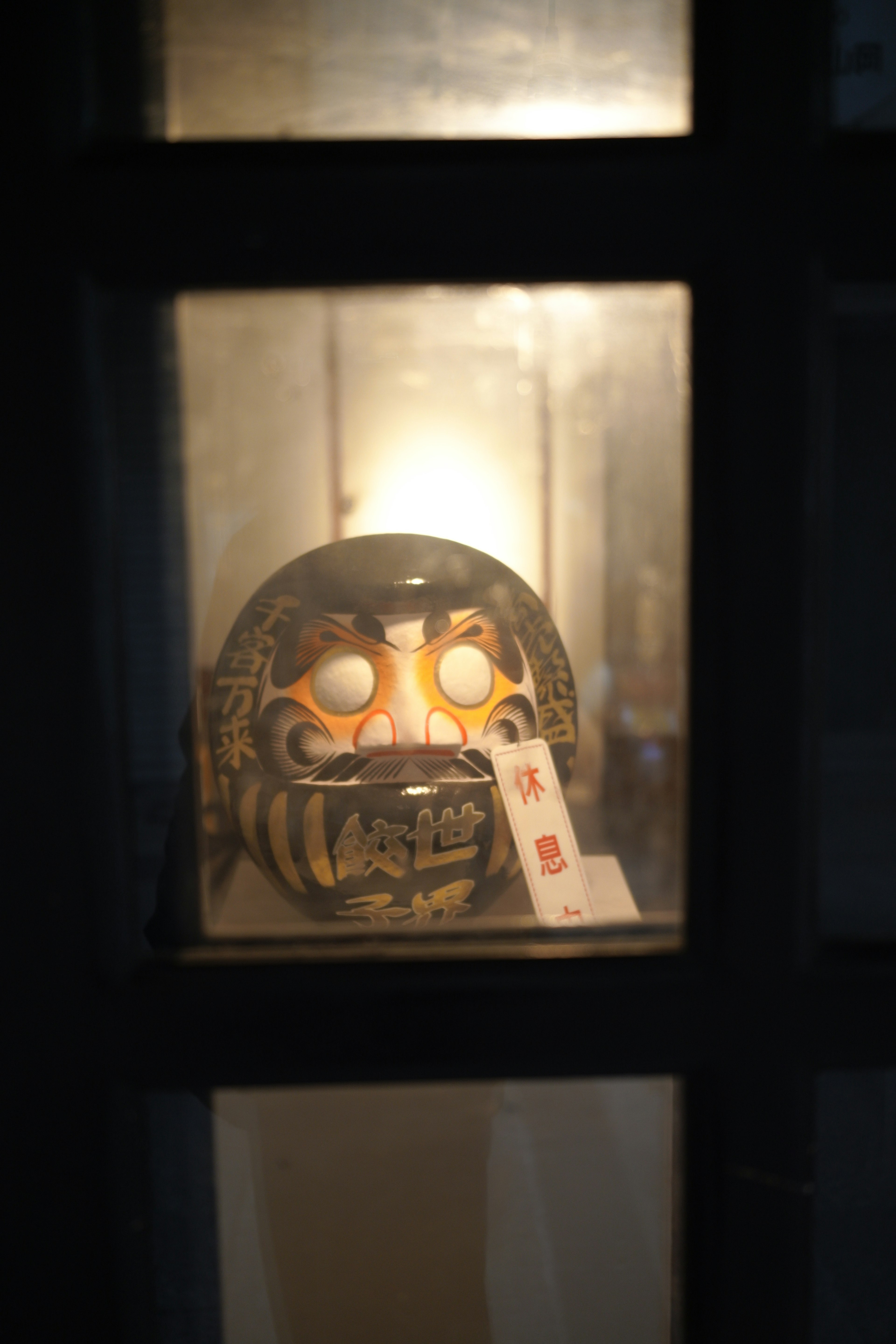 Traditional mask illuminated behind a window