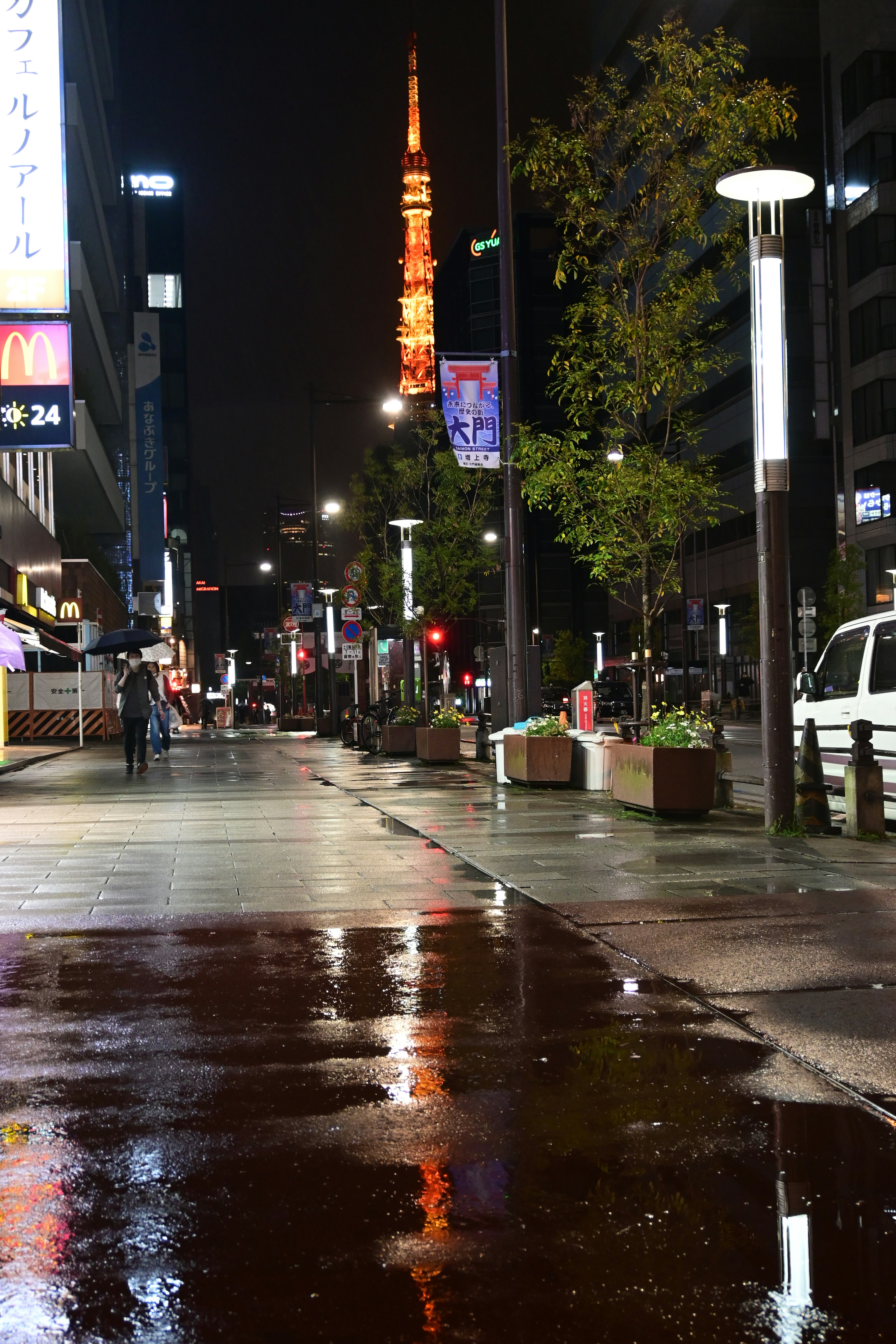 Nachtansicht einer Straße in Tokio mit Reflexion der Tokyo Tower und Pfützen