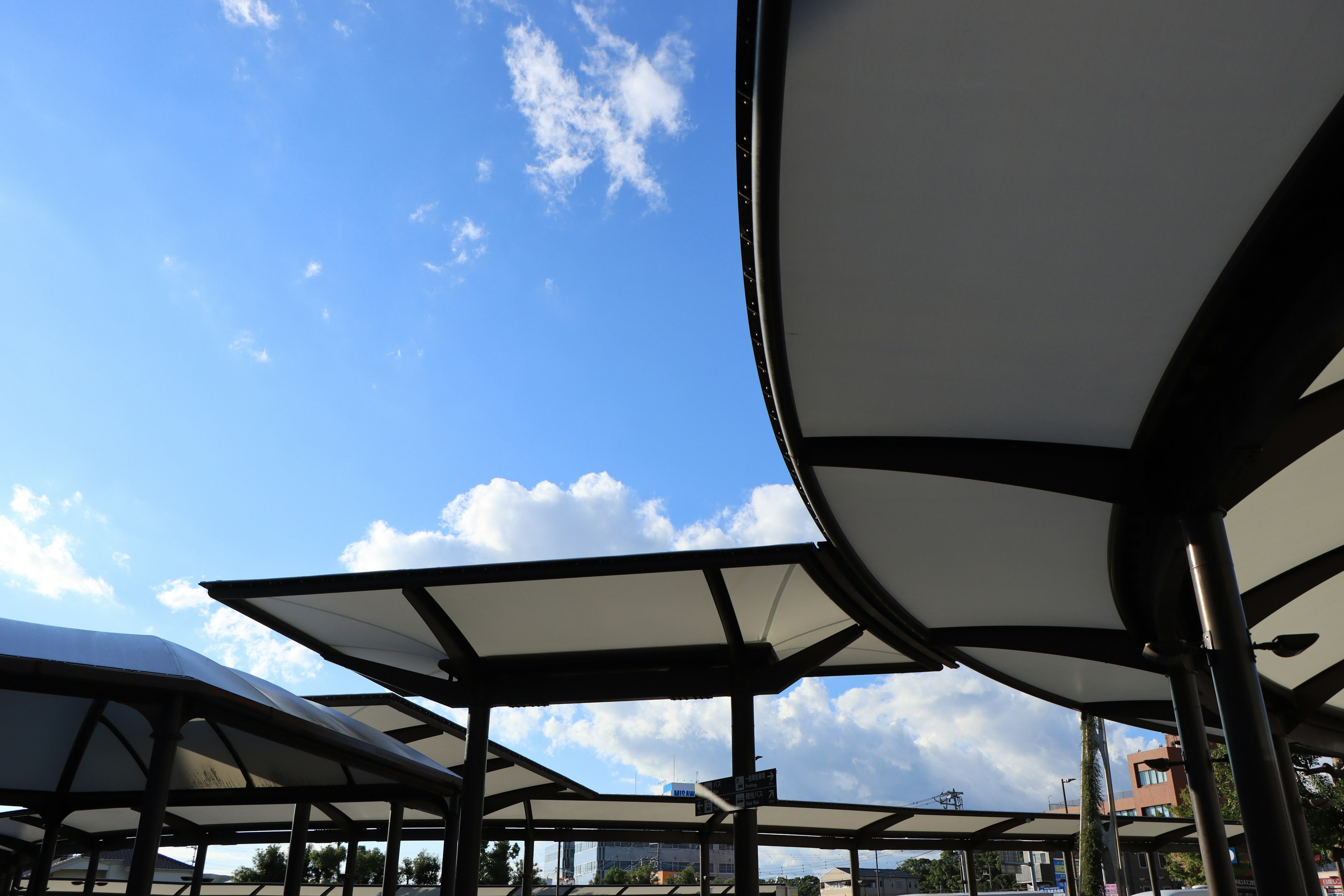 Modern pavilion roofs under a clear blue sky