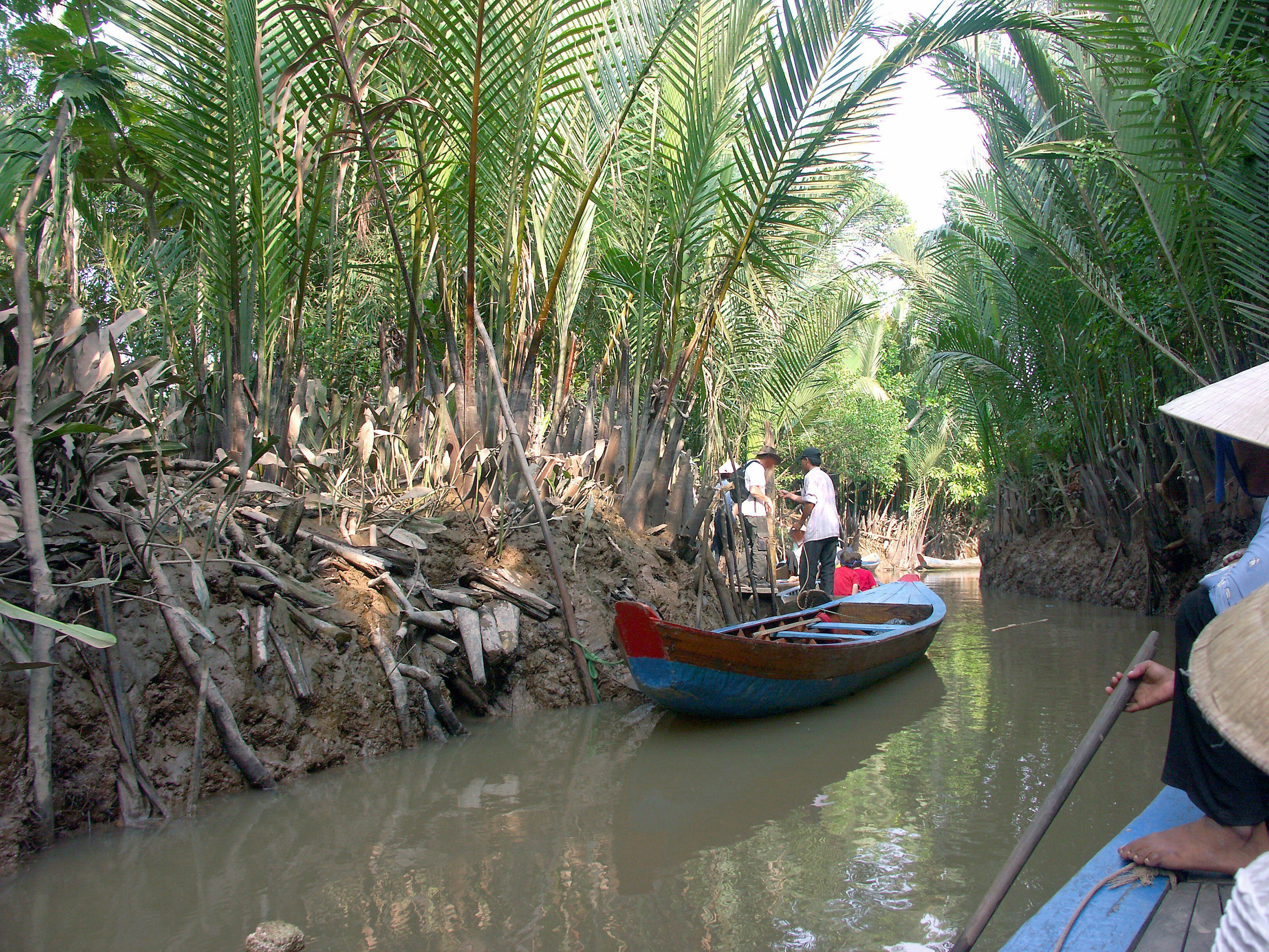 Una pequeña embarcación flotando en un canal verde