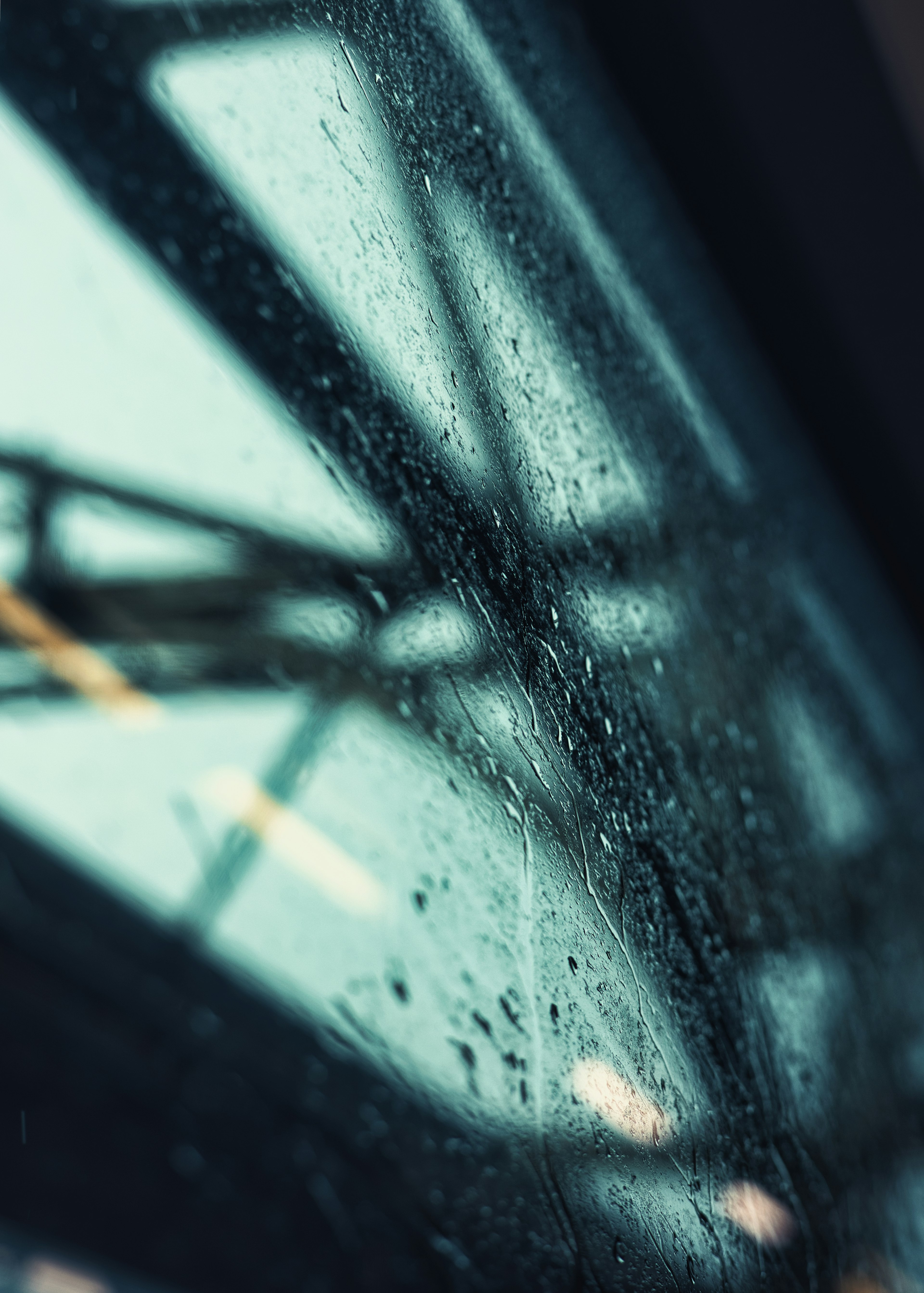 View through a rain-specked window showcasing industrial structures