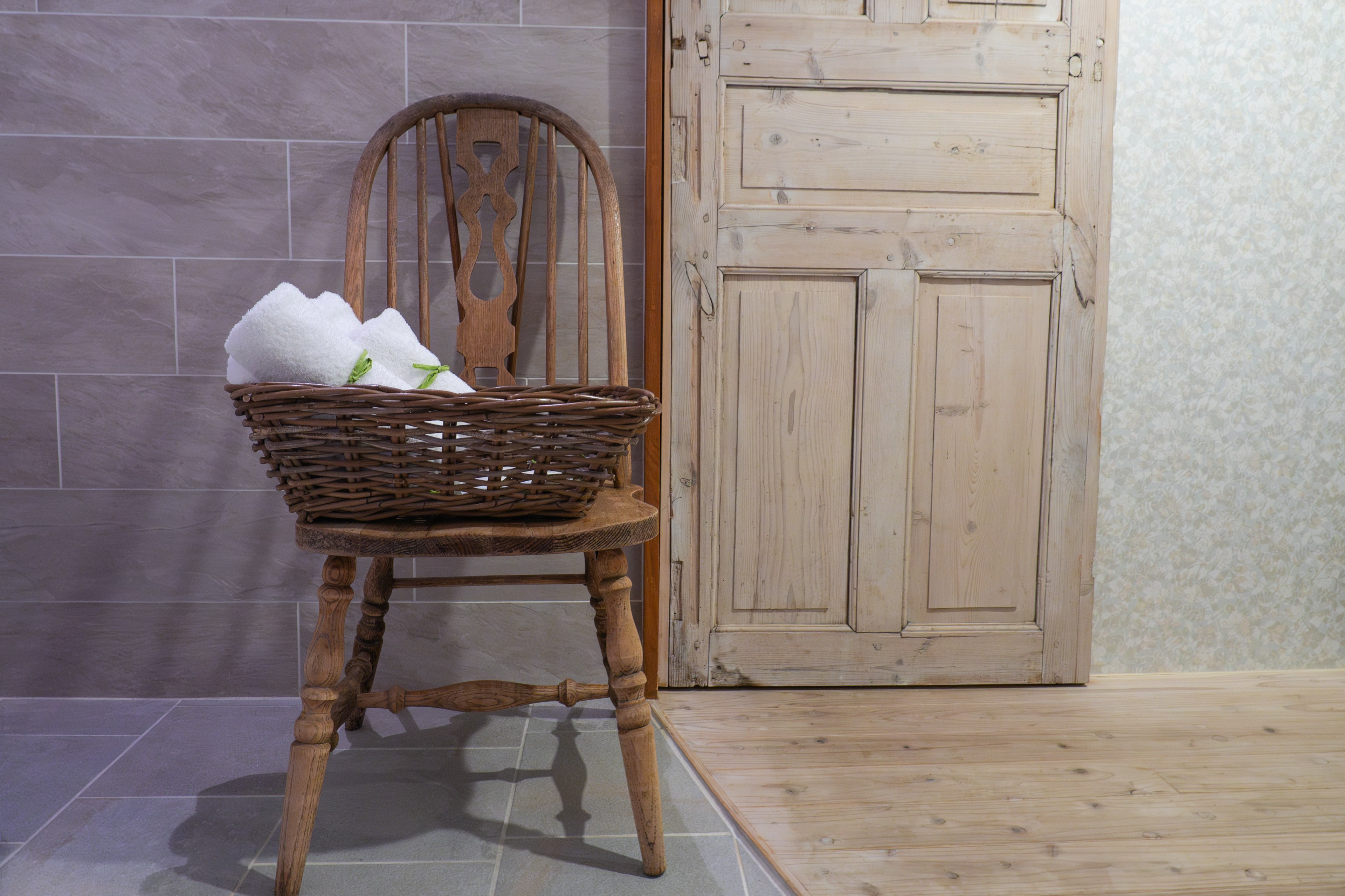 A wooden chair with a basket placed on it in an indoor setting